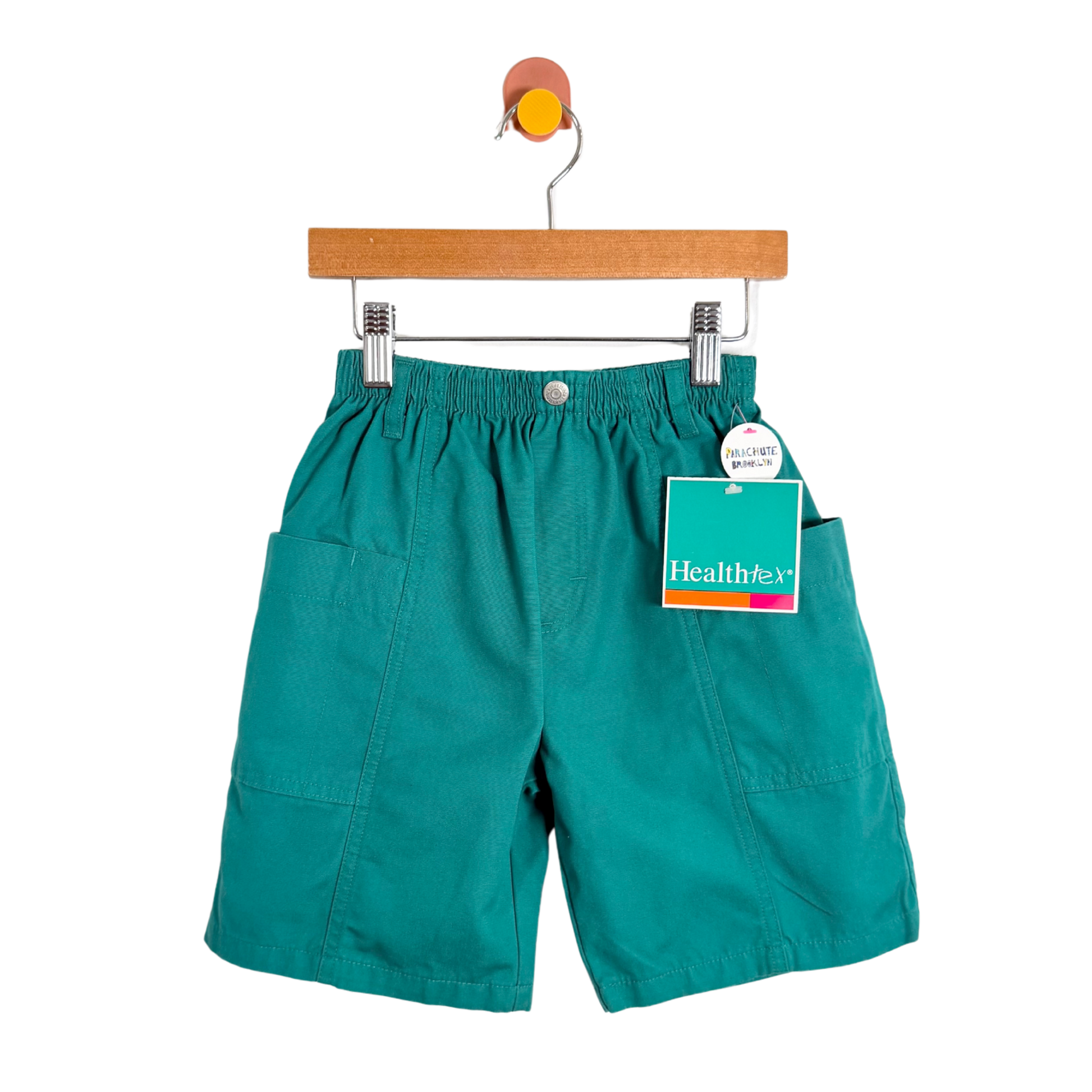 Teal shorts on a hanger with a tag on a white background