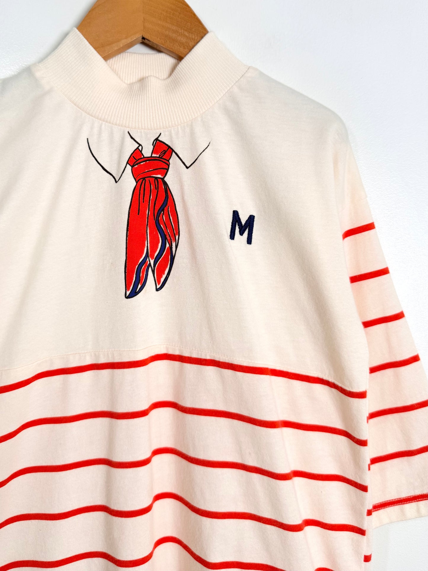 White dress with red stripes and a red dress graphic on a hanger