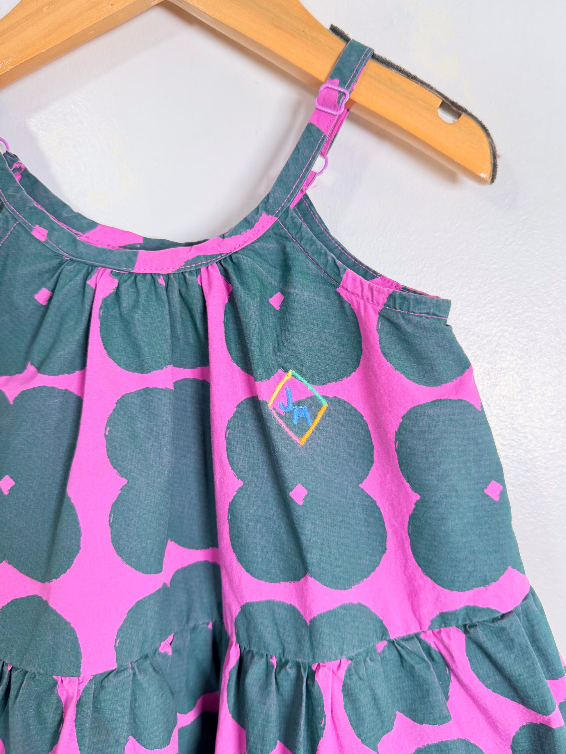 Pink and green top on a hanger against a white background