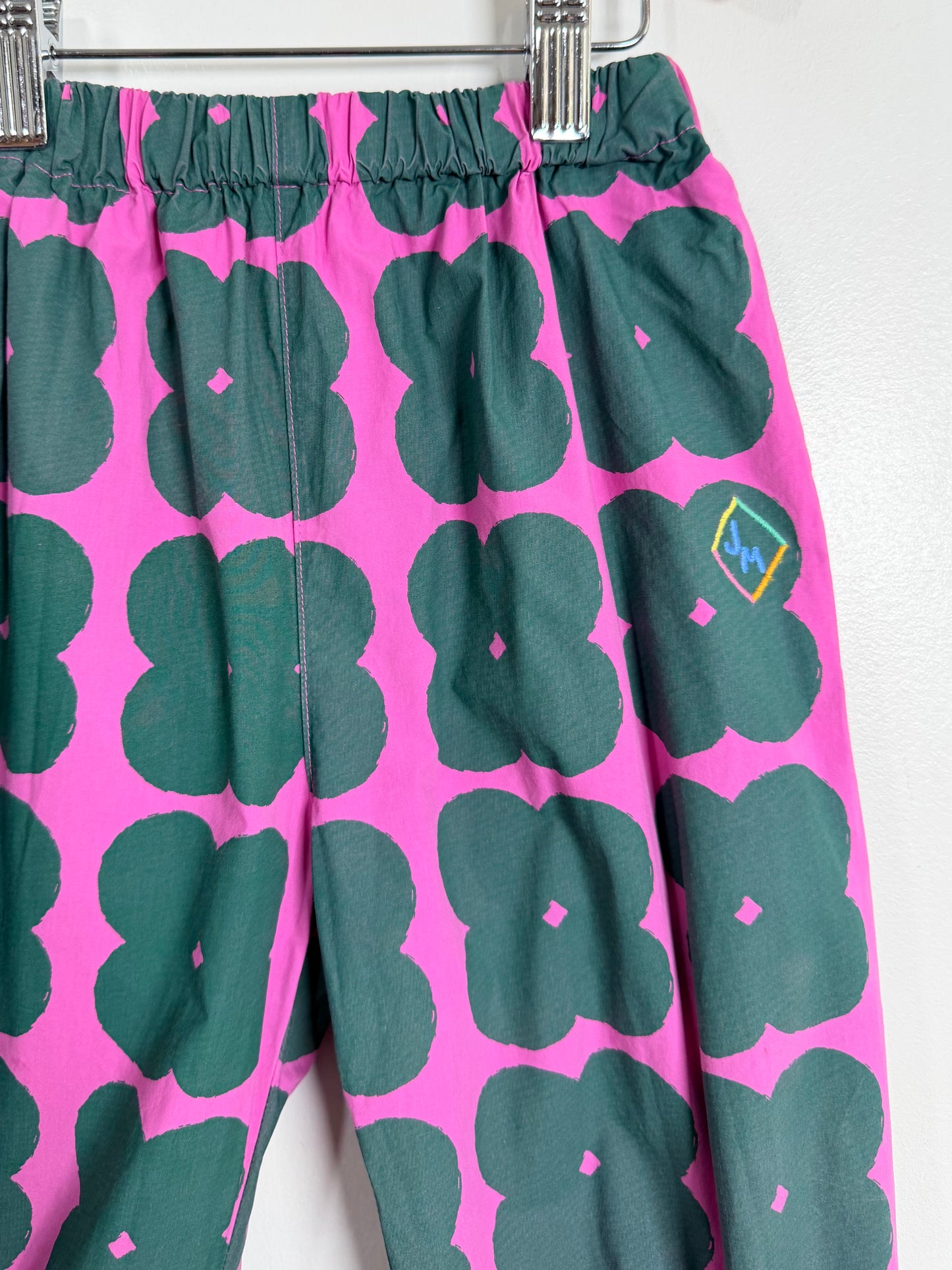 Pink pants with green abstract pattern on a white background