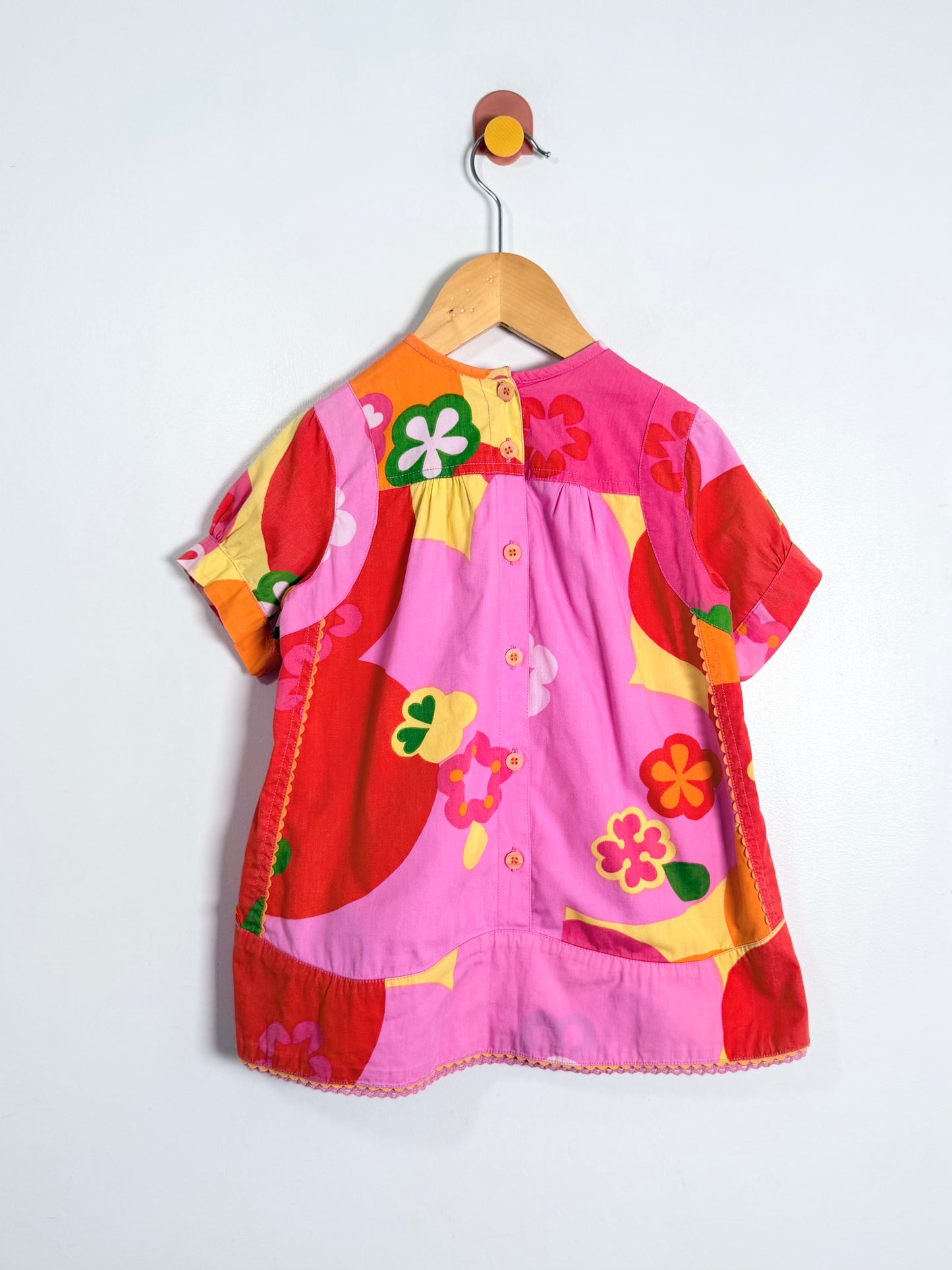 Colorful children's dress with floral patterns on a white background