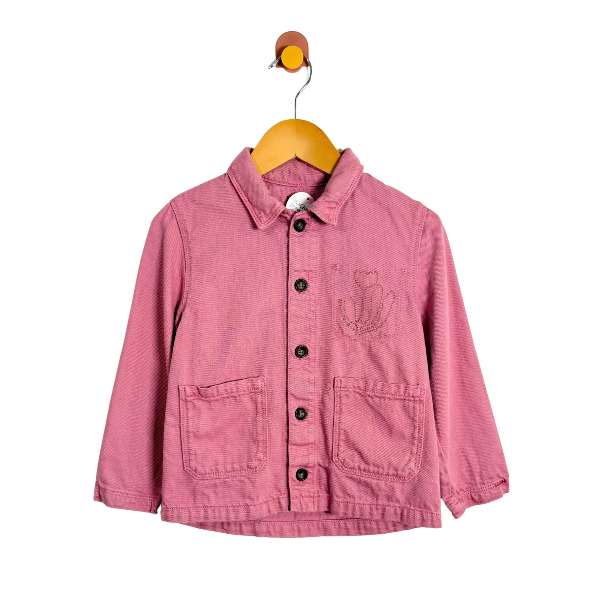 Pink jacket with a floral design on a hanger against a white background