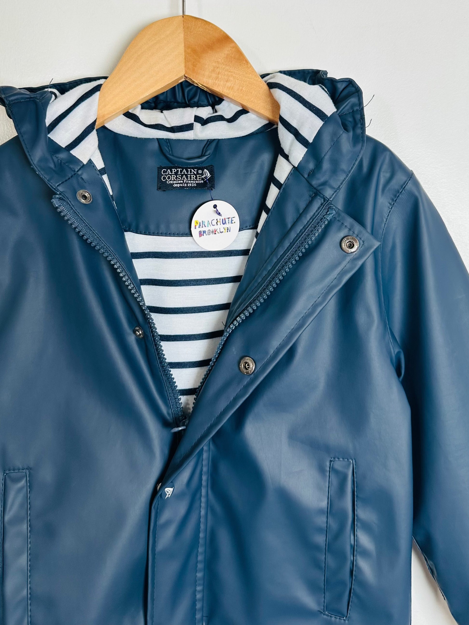 Blue raincoat with striped shirt underneath on a hanger