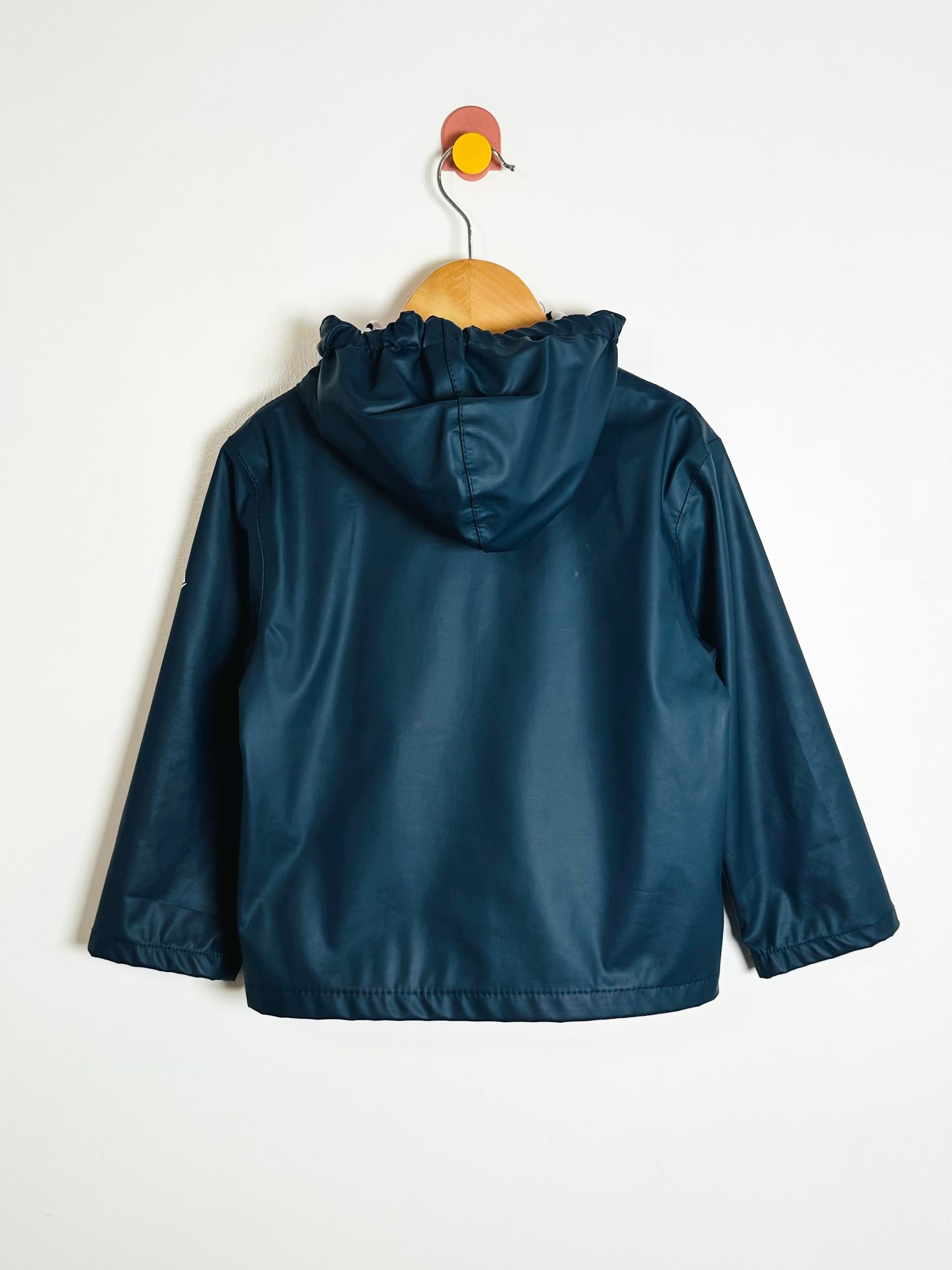 Blue raincoat on a hanger against a white background