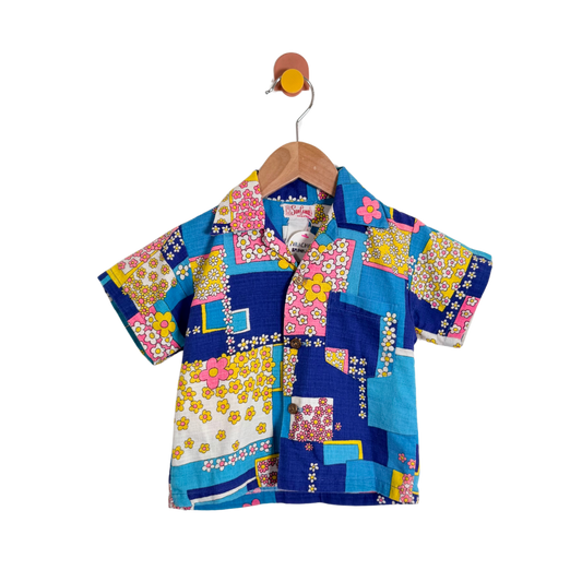 Colorful patchwork shirt on a hanger against a white background