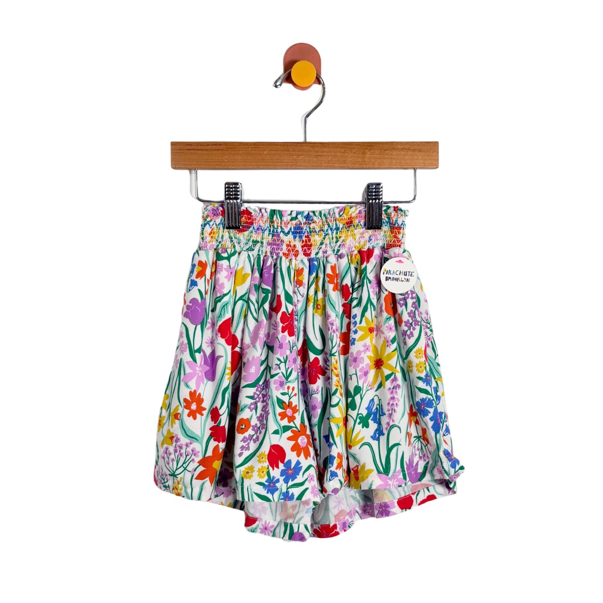 Colorful floral shorts on a hanger against a white background