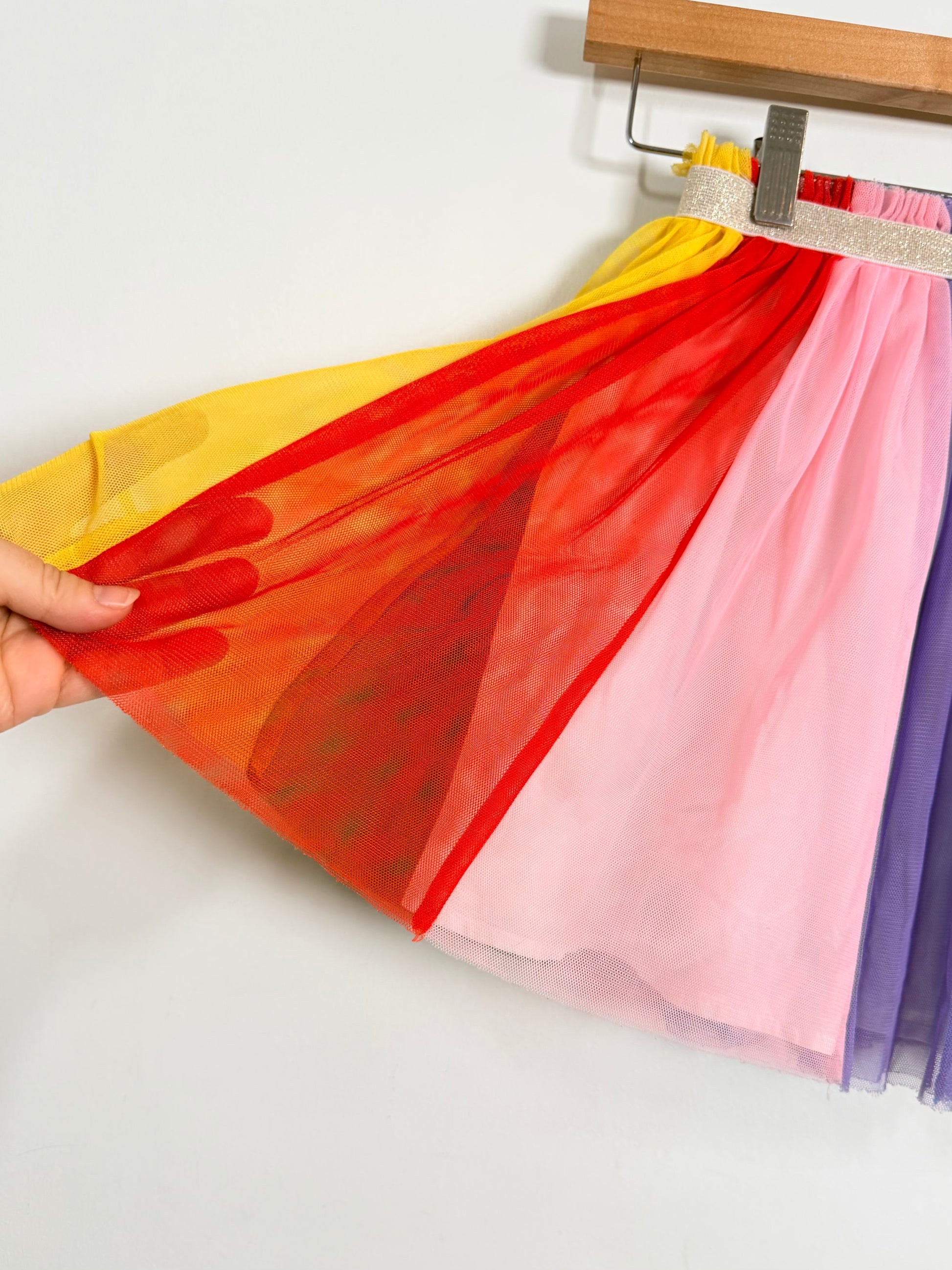 Colorful tulle skirt on a hanger against a white background