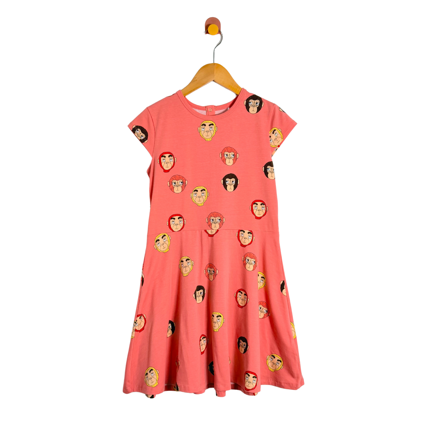 Coral dress with monkey face pattern on a hanger against a white background