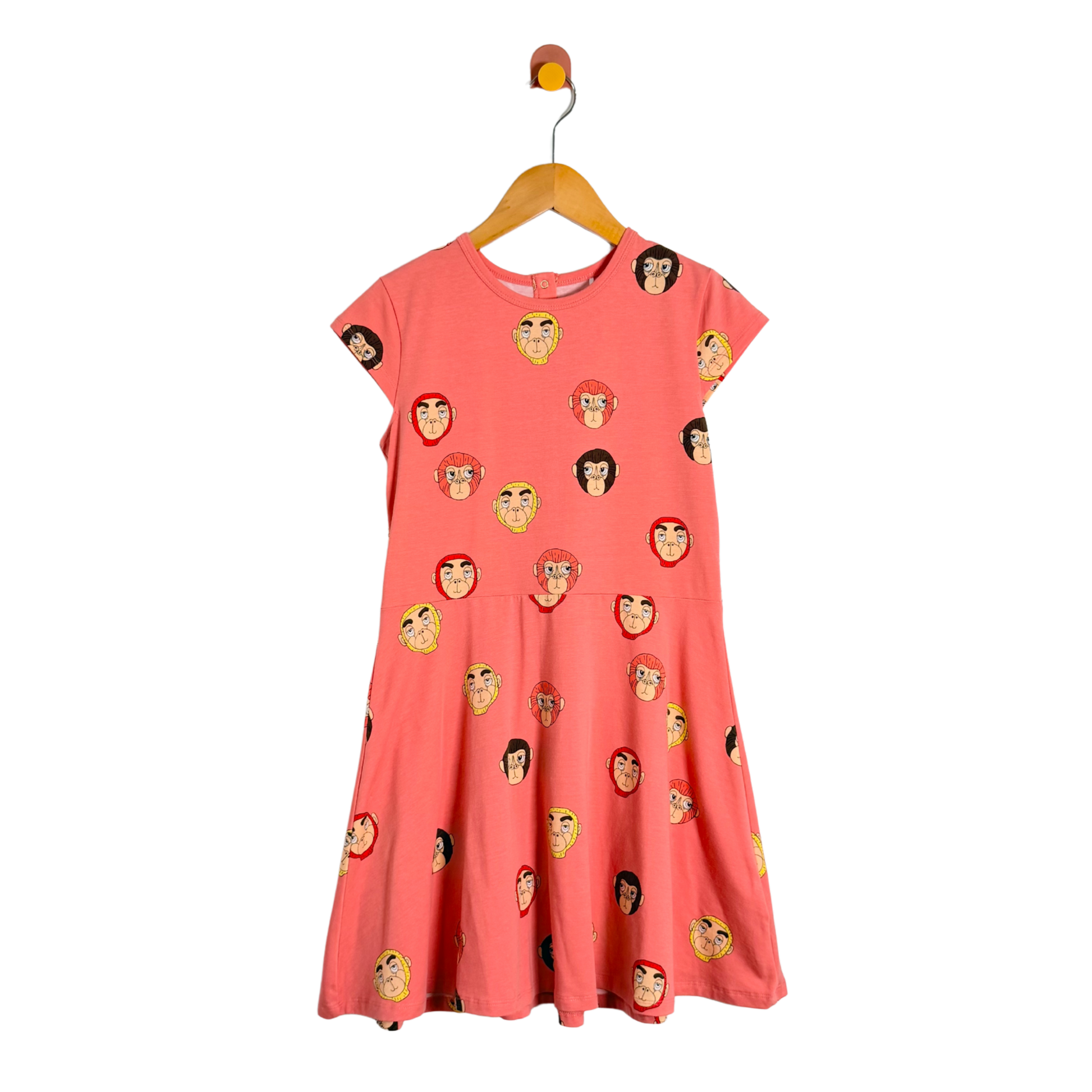 Coral dress with monkey face pattern on a hanger against a white background