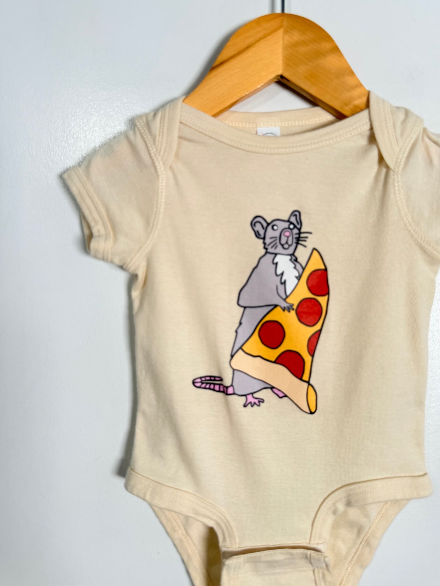 Beige baby onesie with a graphic of a mouse holding a pizza slice on a hanger against a white background.