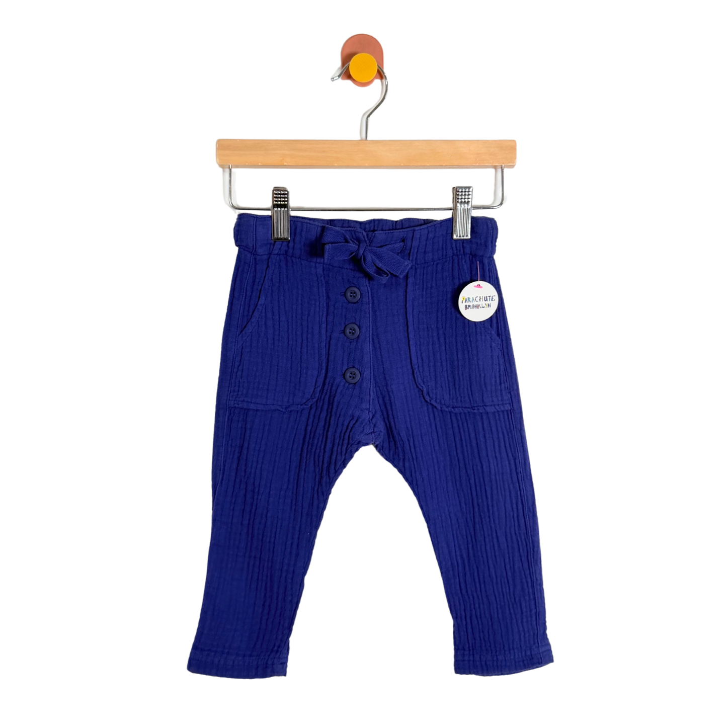Blue ribbed baby pants on a hanger with a white background