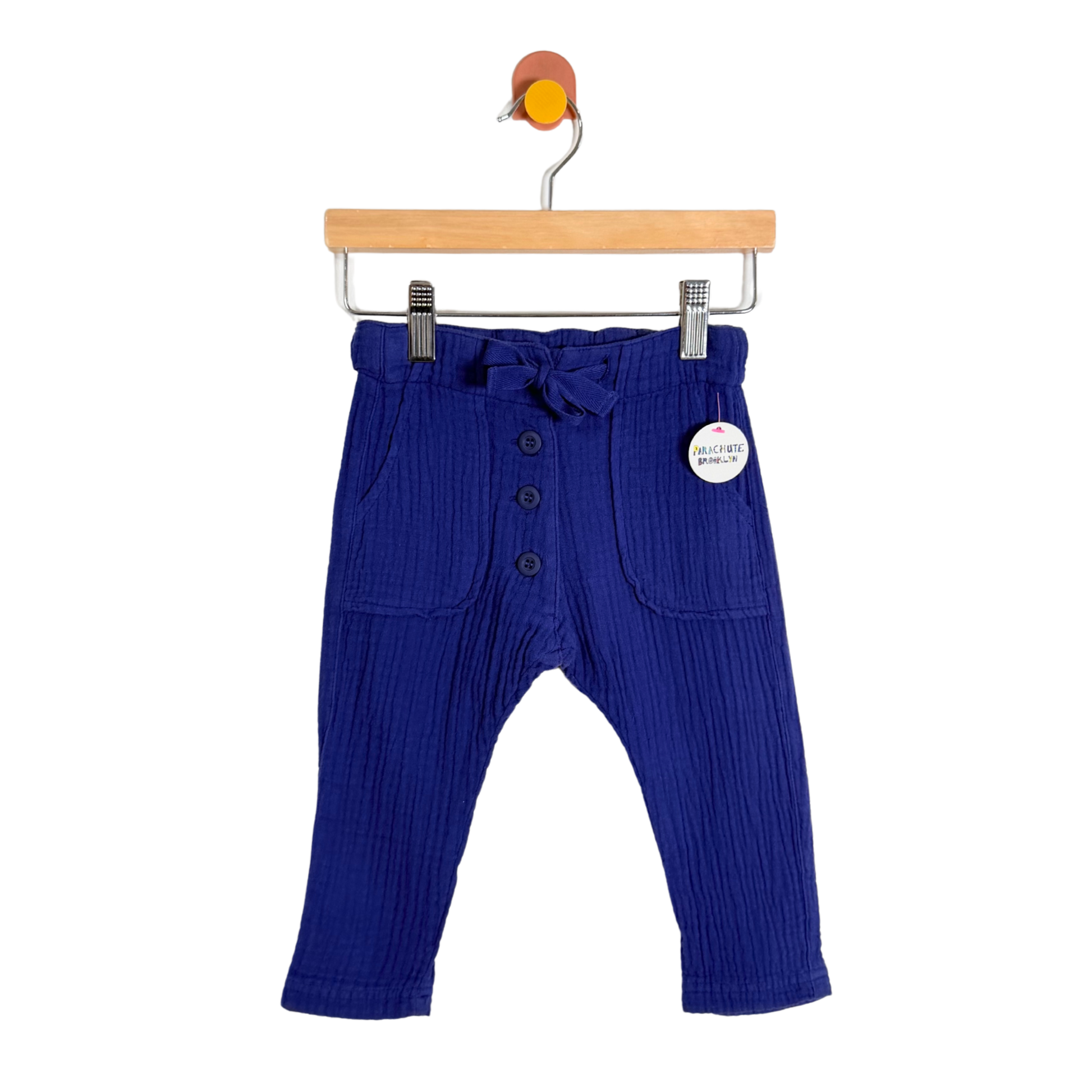 Blue ribbed baby pants on a hanger with a white background