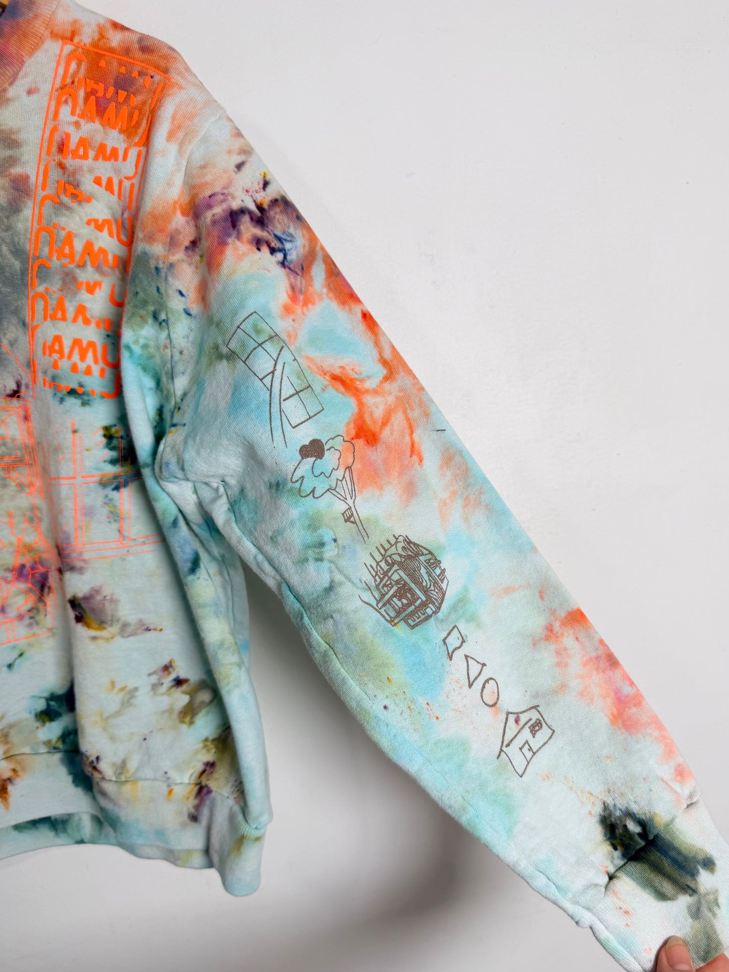 Colorful tie-dye shirt with text and graphics on a white background