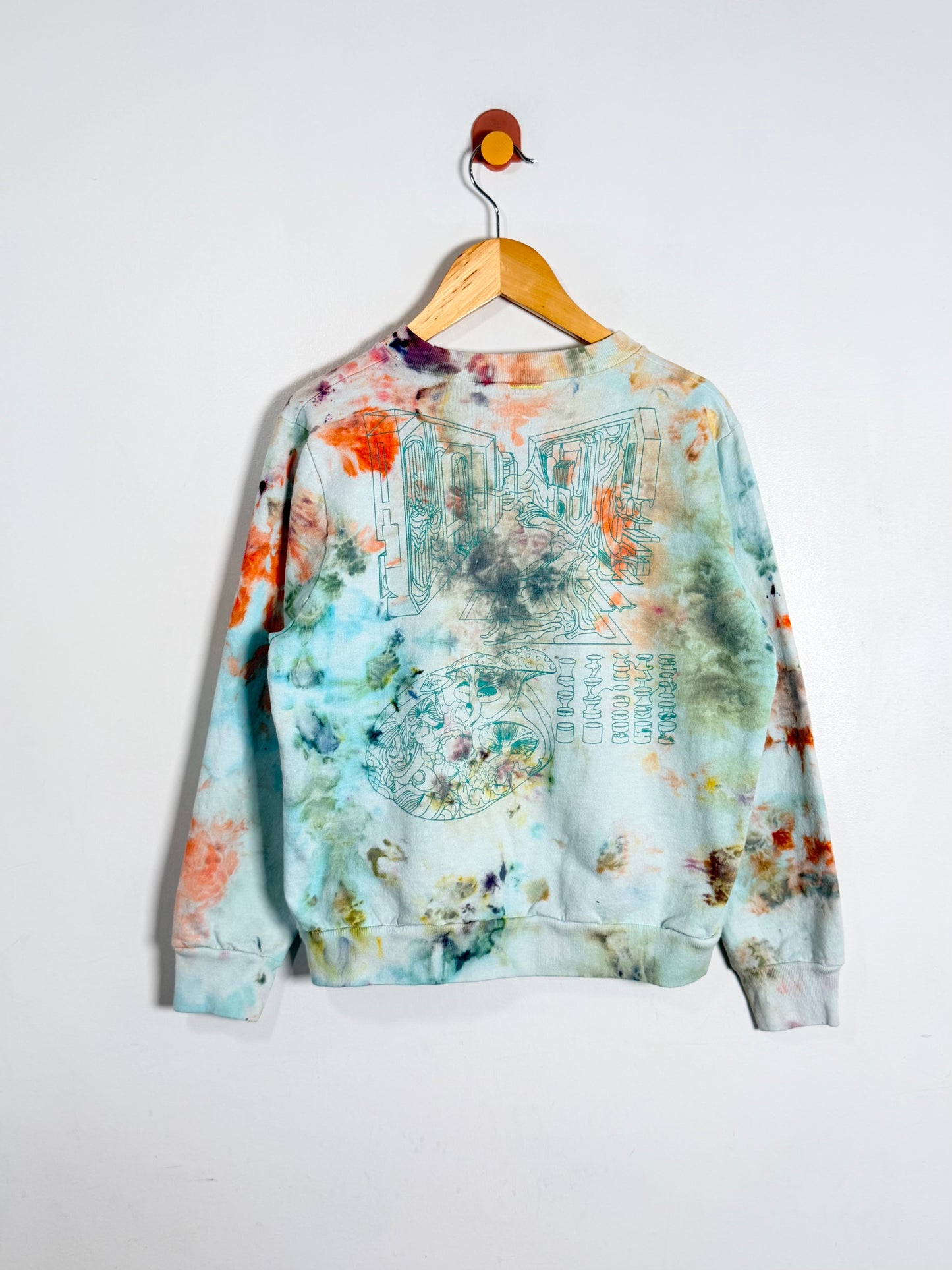 Colorful sweatshirt with abstract design on a hanger against a white background