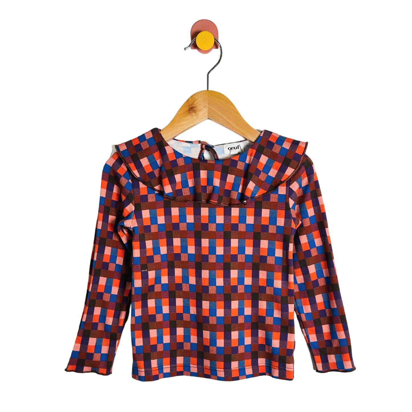 Plaid shirt on a wooden hanger against a white background