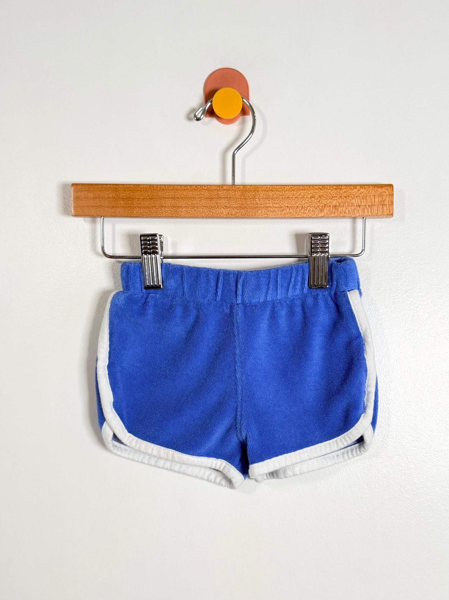 Blue shorts on a hanger against a white background
