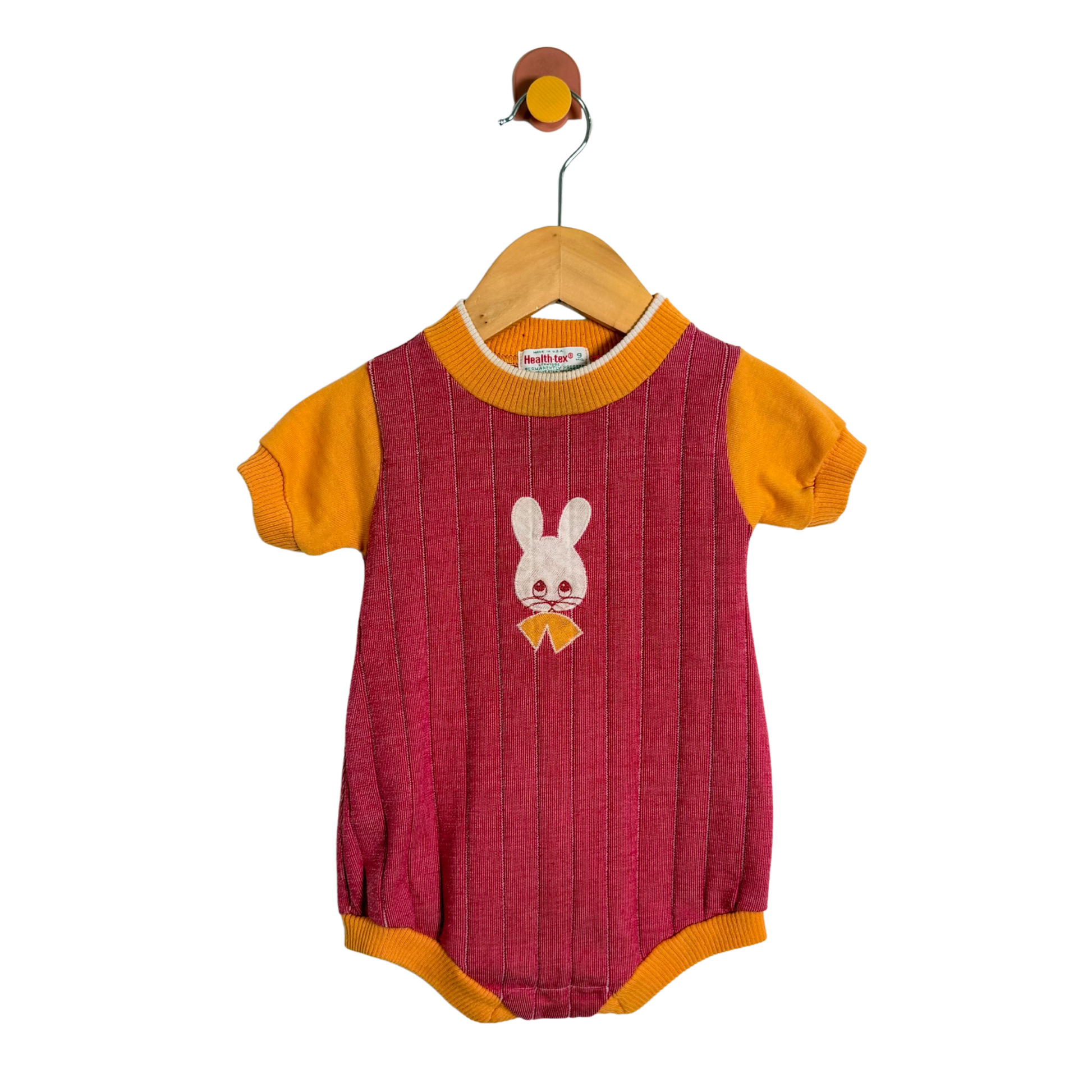 Baby romper with bunny design on a hanger against a white background