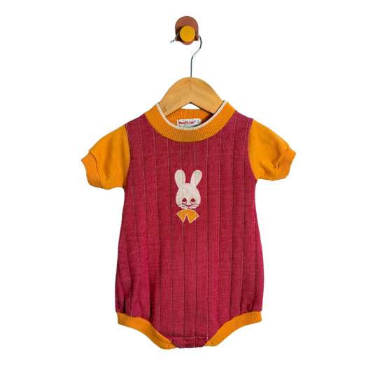 Baby romper with bunny design on a hanger against a white background