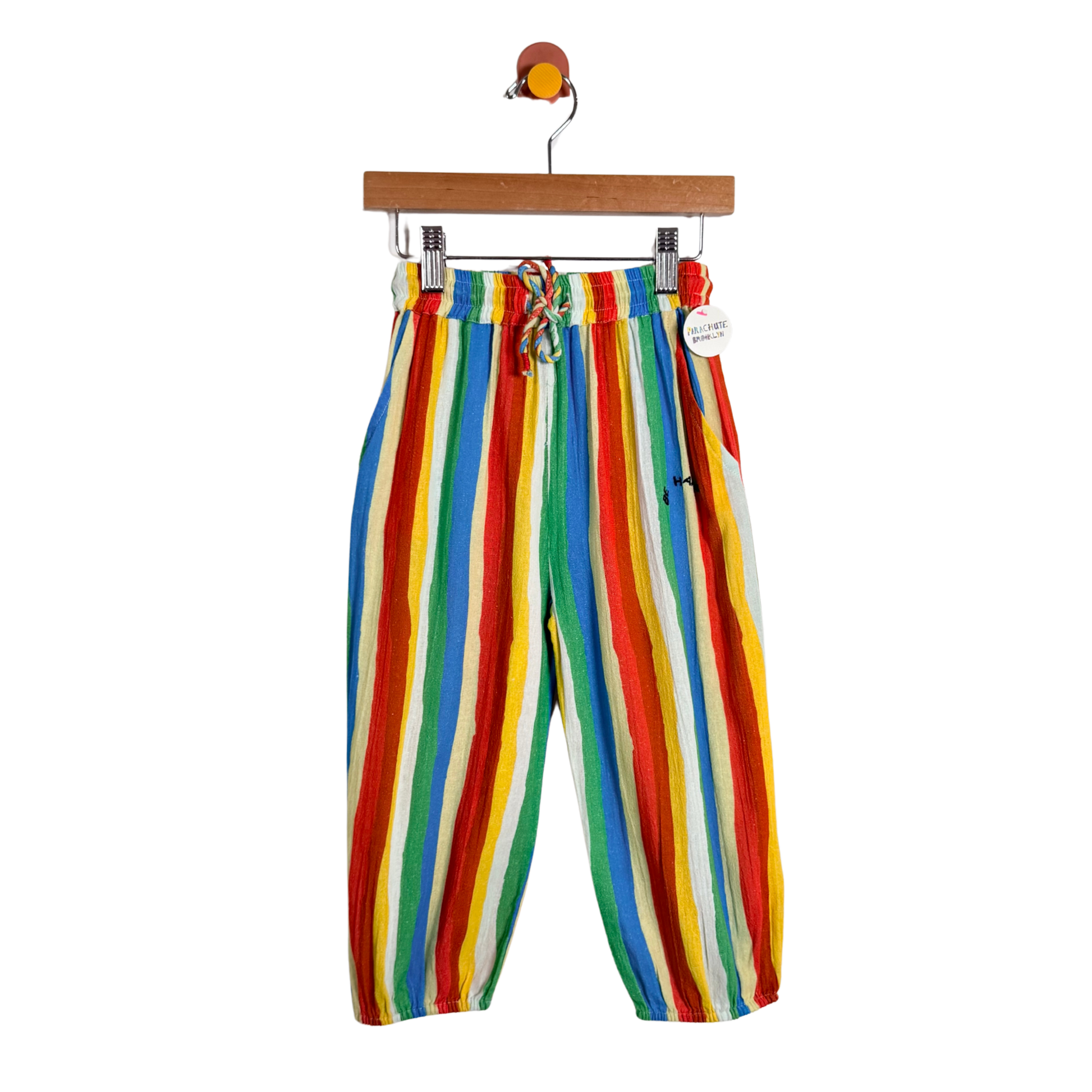 Colorful striped pants on a hanger against a white background