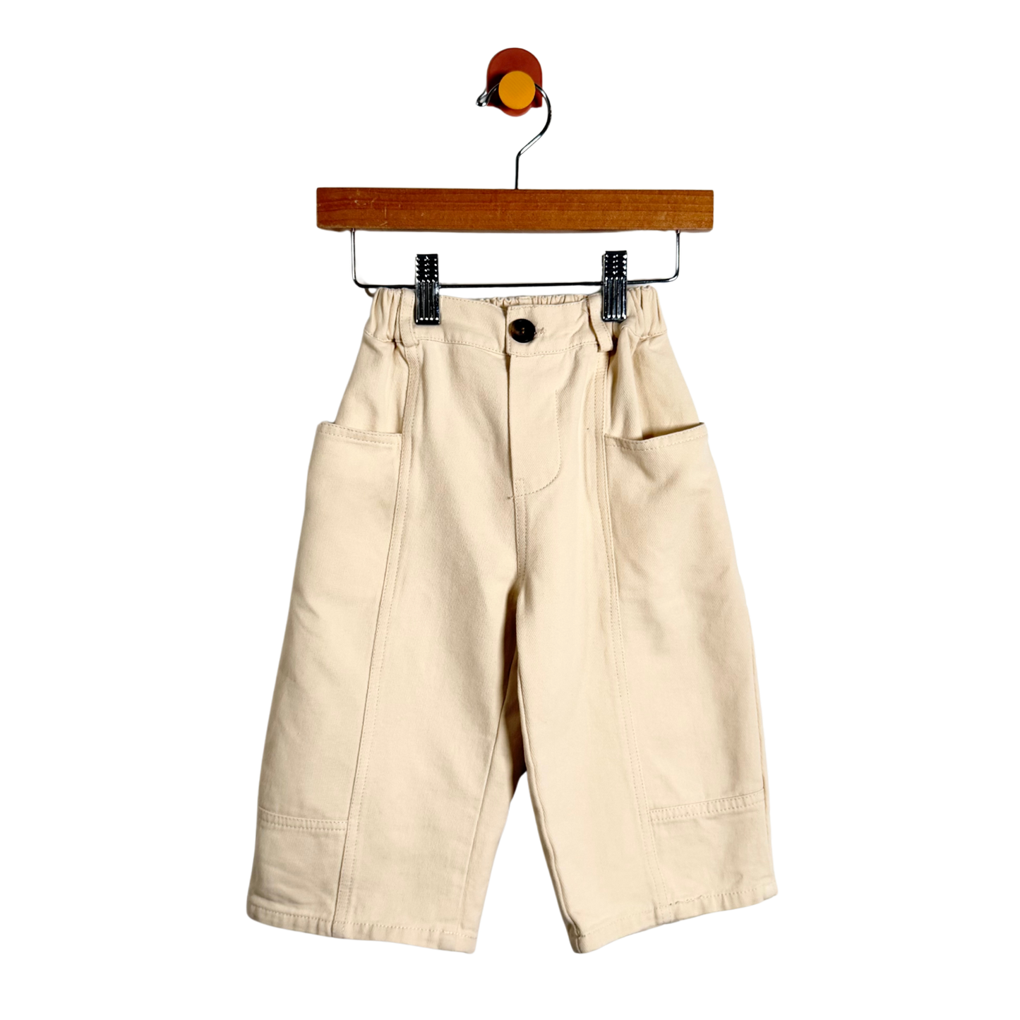Beige pants on a hanger against a white background
