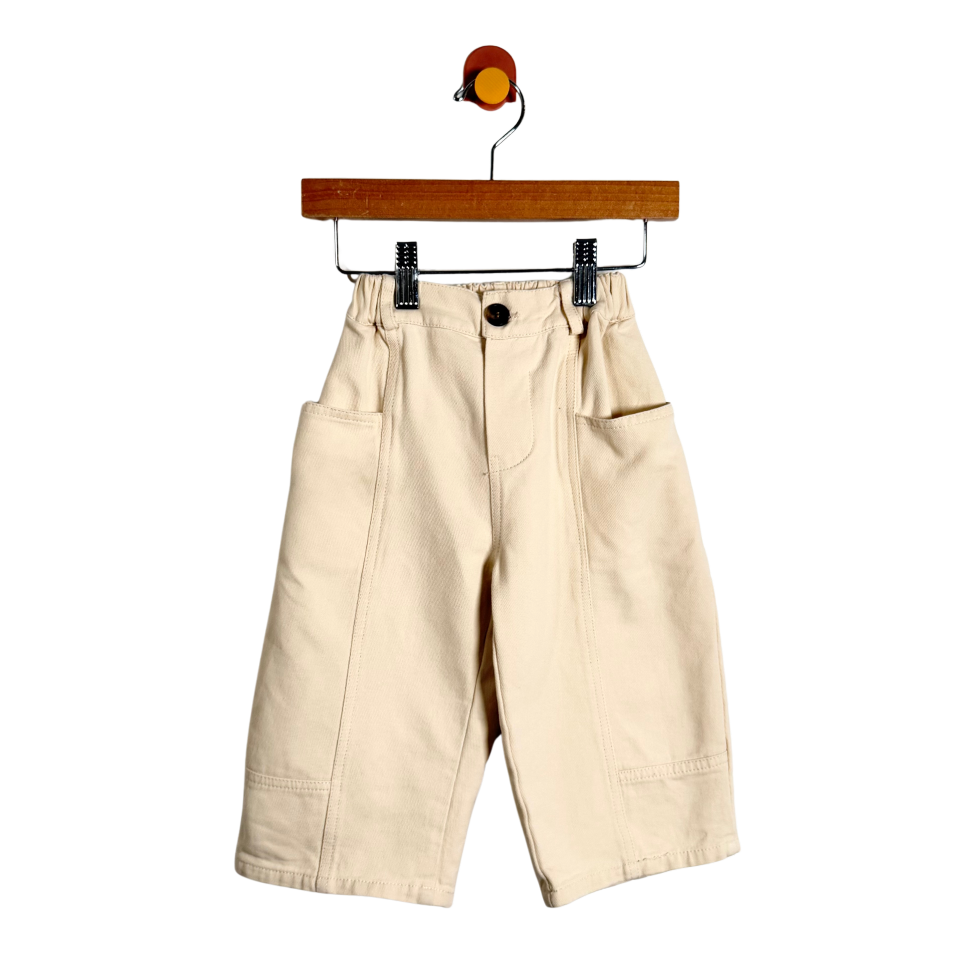 Beige pants on a hanger against a white background