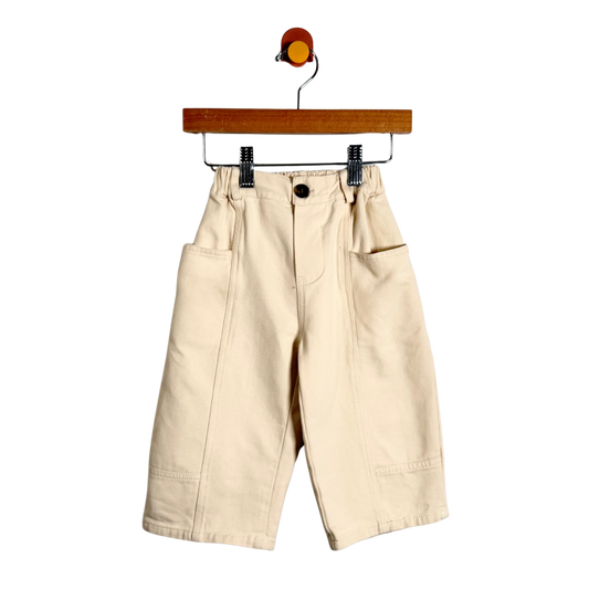 Beige pants on a hanger against a white background