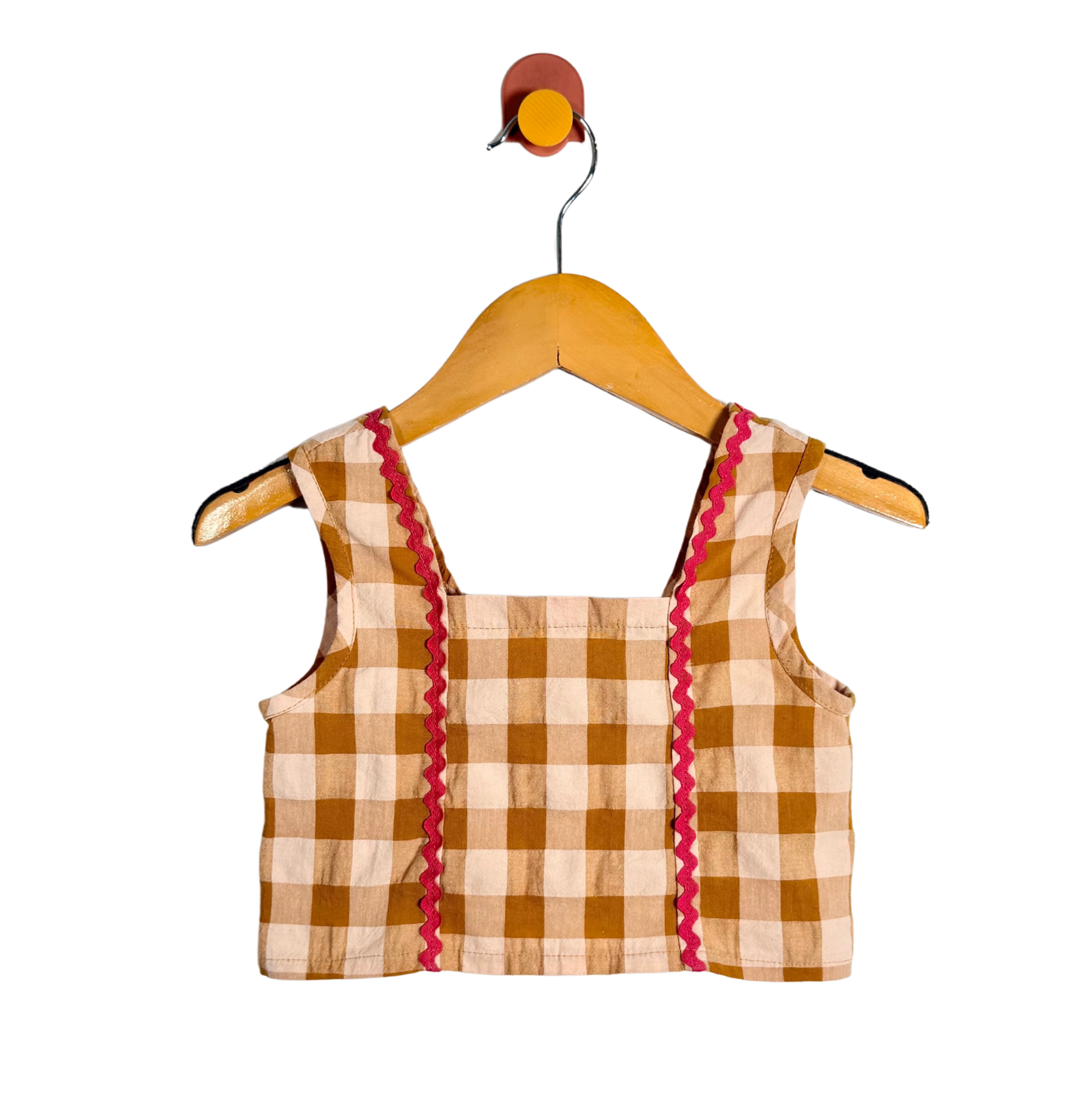 Plaid top with red trim on a wooden hanger against a white background