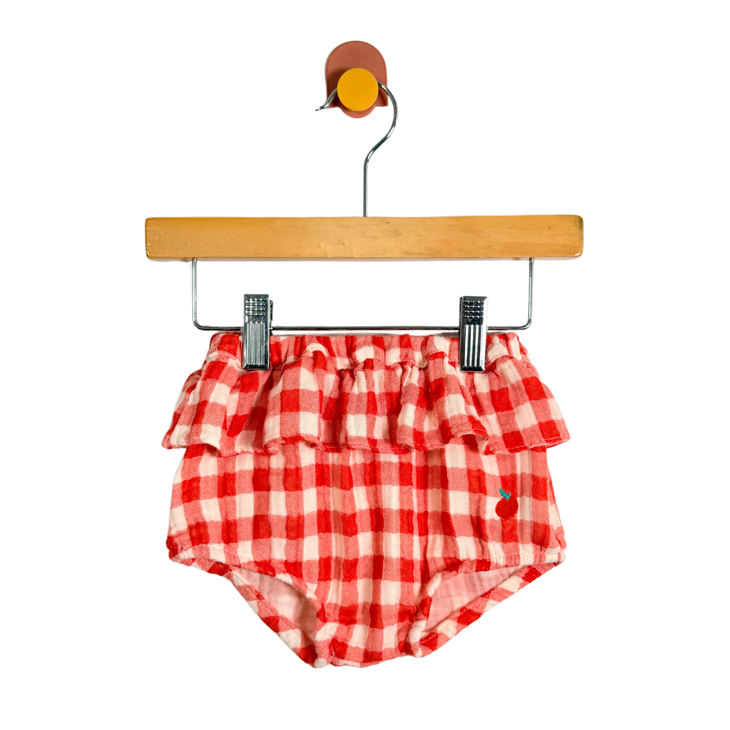 Red and white checkered baby bloomers on a wooden hanger with a white background