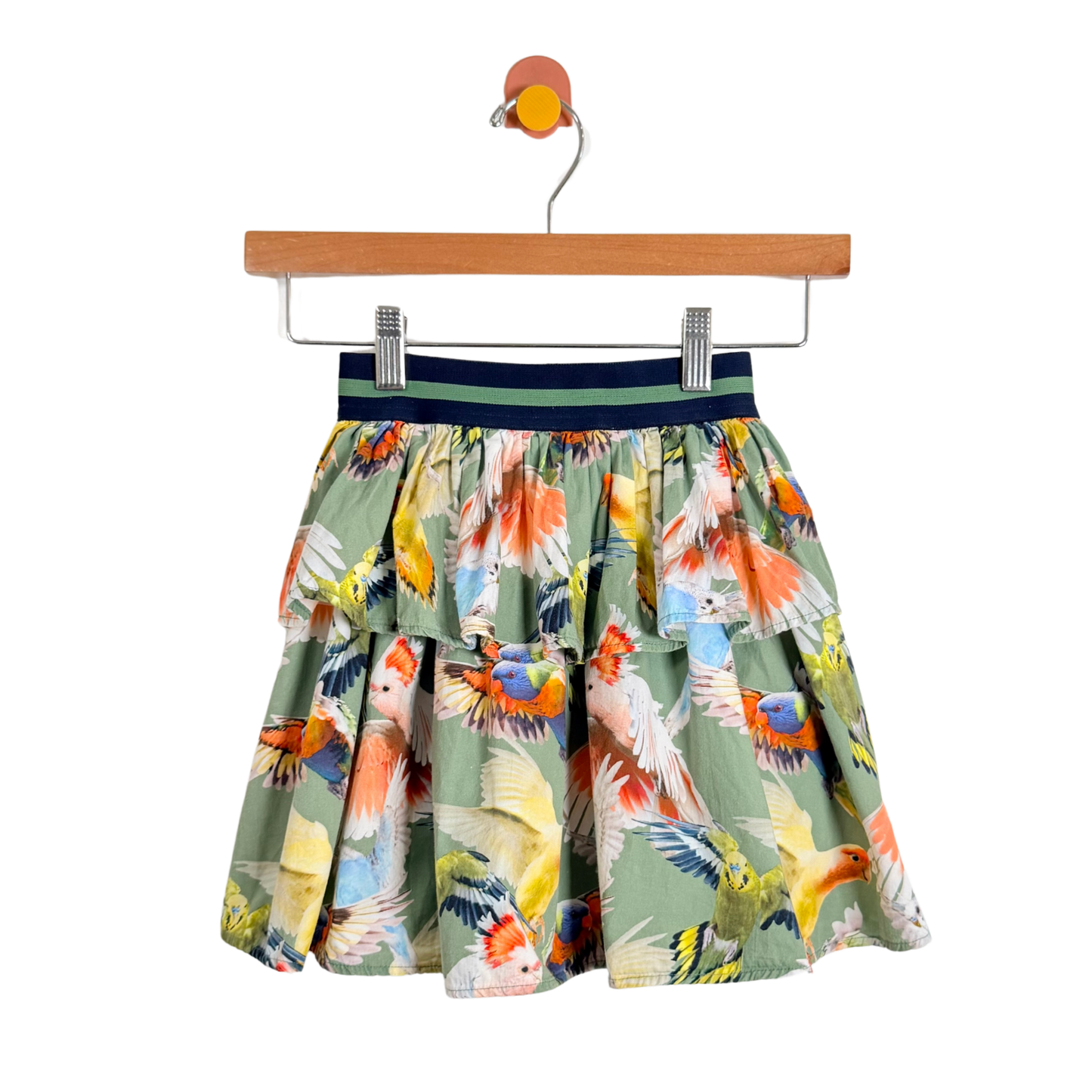 Skirt with parrot pattern on a hanger against a white background