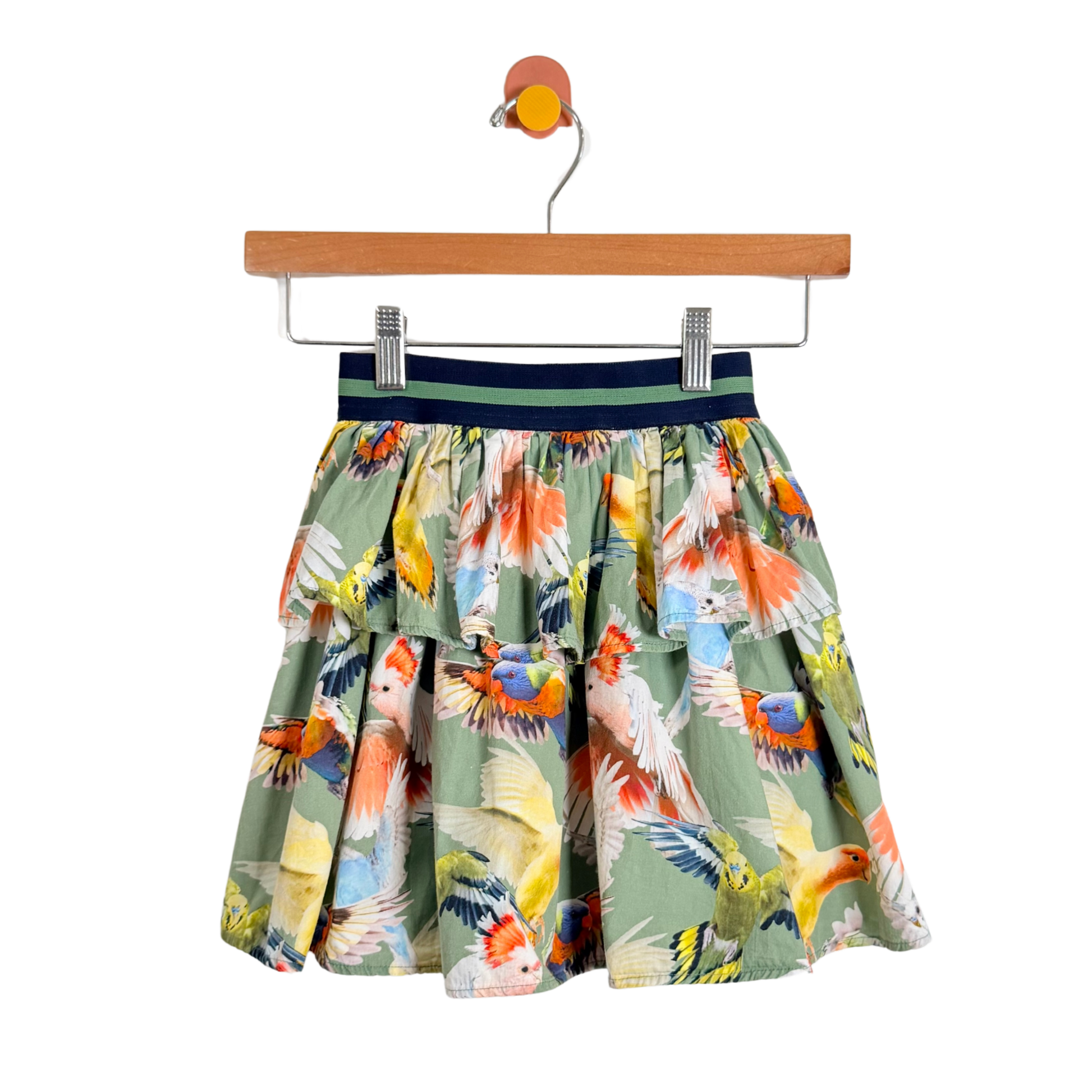 Skirt with parrot pattern on a hanger against a white background