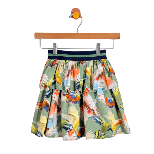 Skirt with parrot pattern on a hanger against a white background