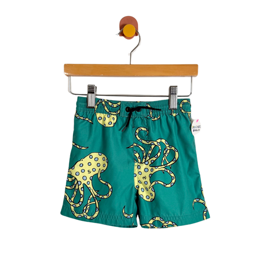 Green shorts with octopus design on a hanger against a white background
