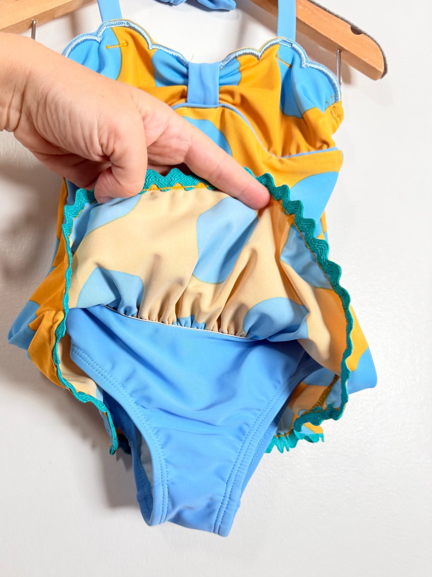 Colorful children's swimsuit with a bow detail on a white background
