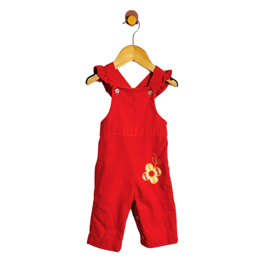 A baby orange overall romper with yellow embroidered floral details on the chest, hanging on a wooden hanger against a plain white background.