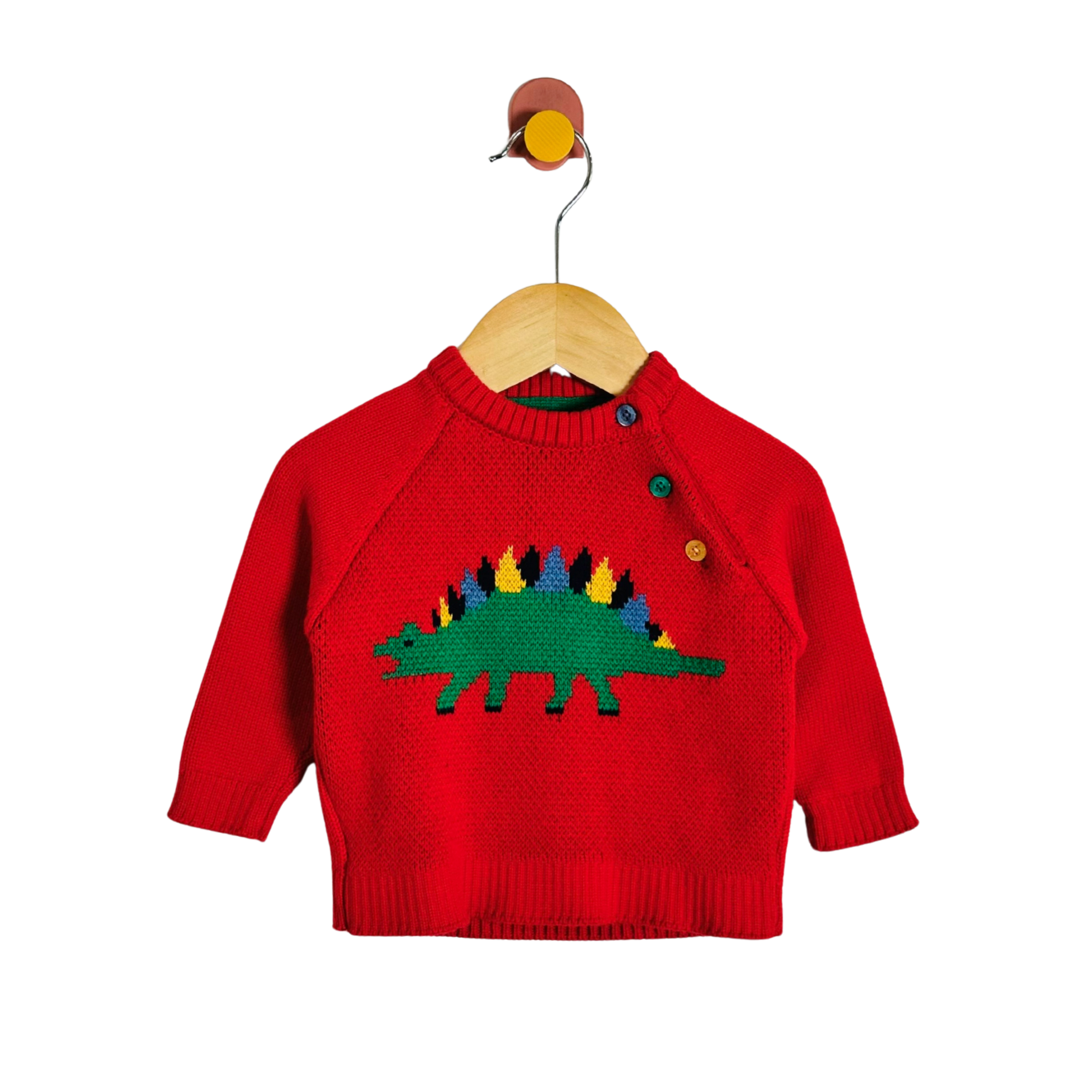 A red knit baby sweater with a colorful knitted dinosaur design on the chest, hanging on a wooden hanger against a plain white background.