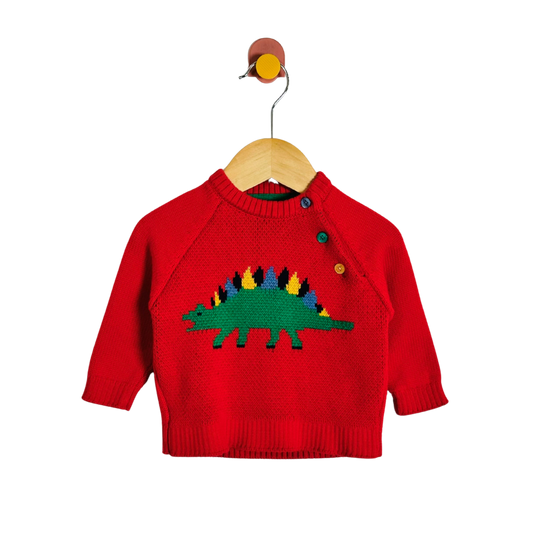 A red knit baby sweater with a colorful knitted dinosaur design on the chest, hanging on a wooden hanger against a plain white background.
