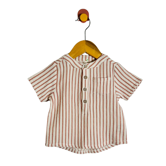 A short-sleeve button-front shirt with vertical red stripes on a cream base, hanging on a wooden hanger against a plain white background.