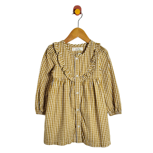 A yellow and white gingham check long-sleeve dress for toddlers, featuring a ruffled collar and front button closure, hanging on a wooden hanger against a plain white background.