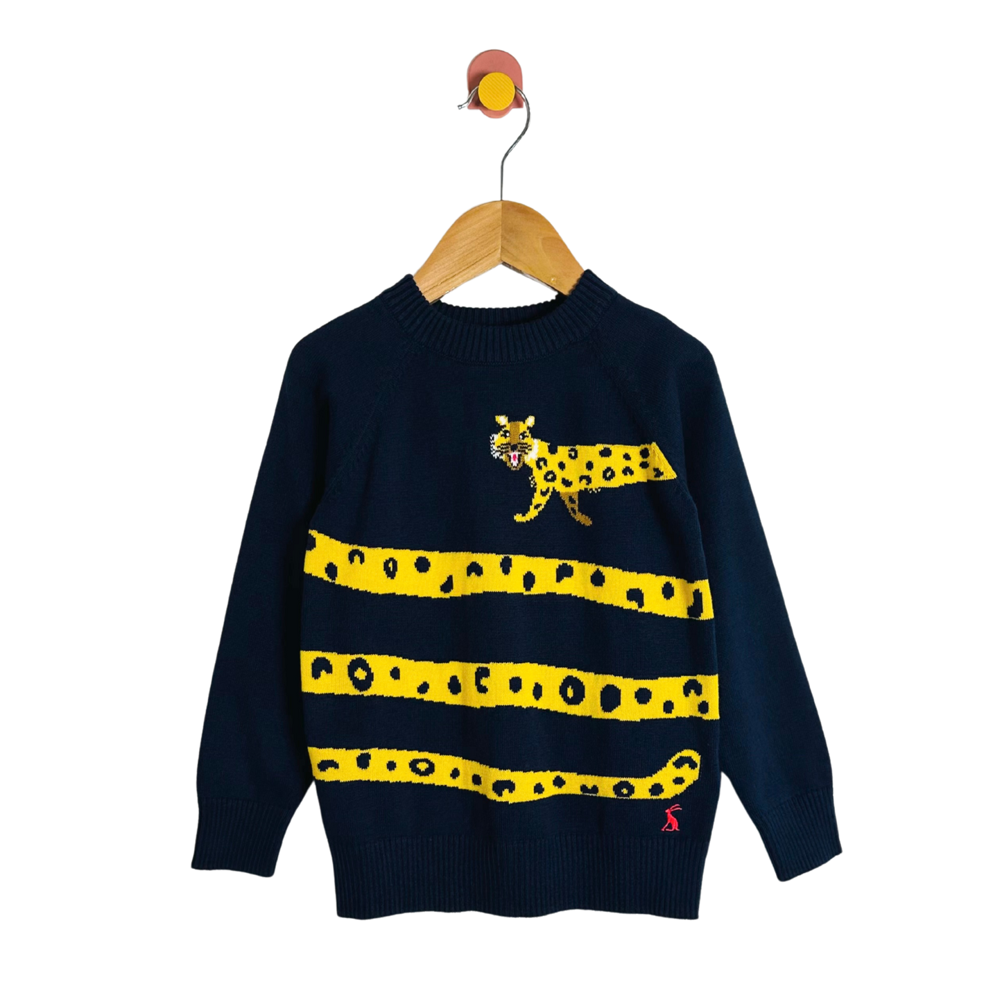 Children's sweater with a leopard design on a hanger against a white background