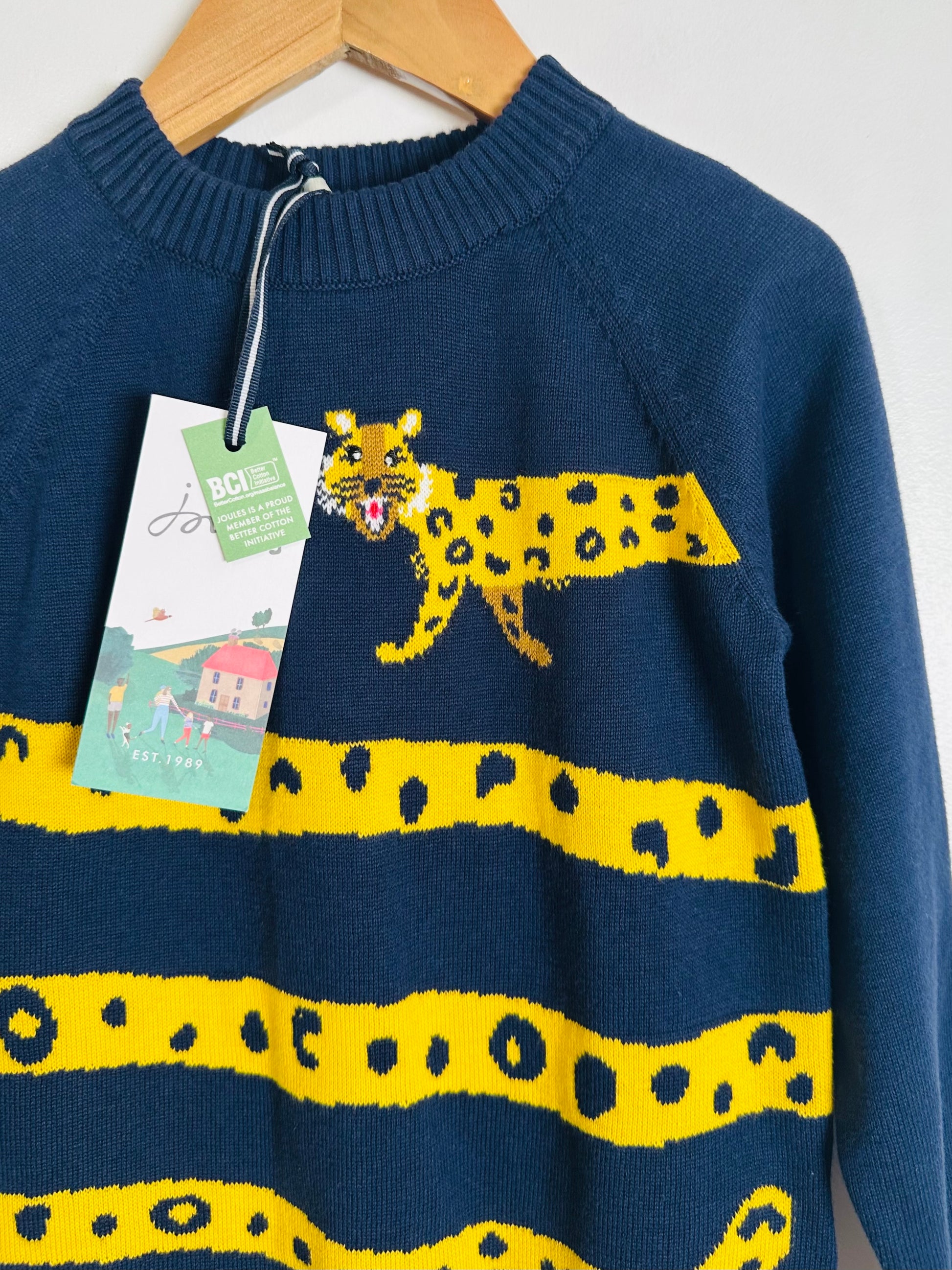 Blue sweater with yellow leopard design on a hanger