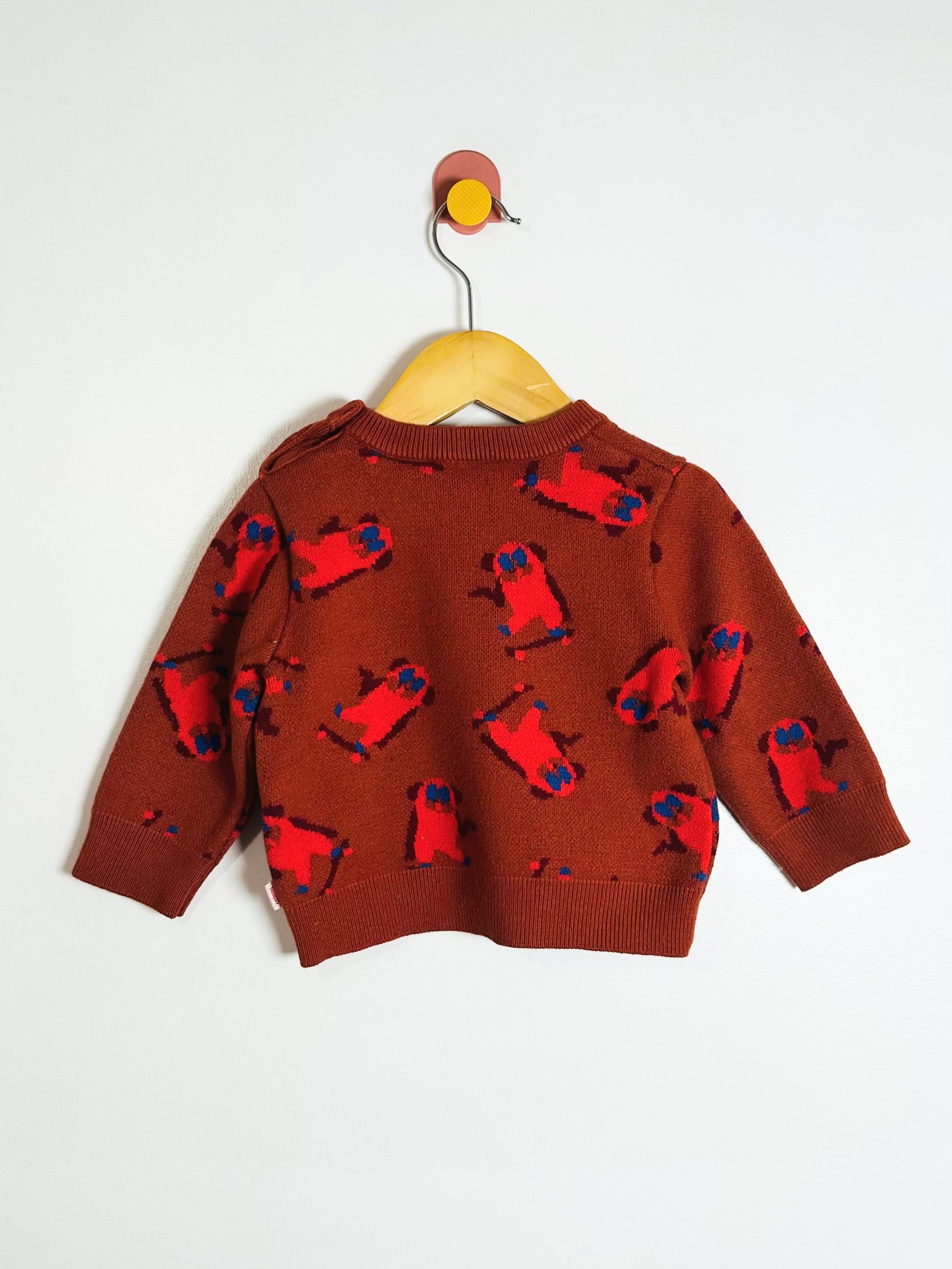 Brown sweater with red and blue pattern on a white background