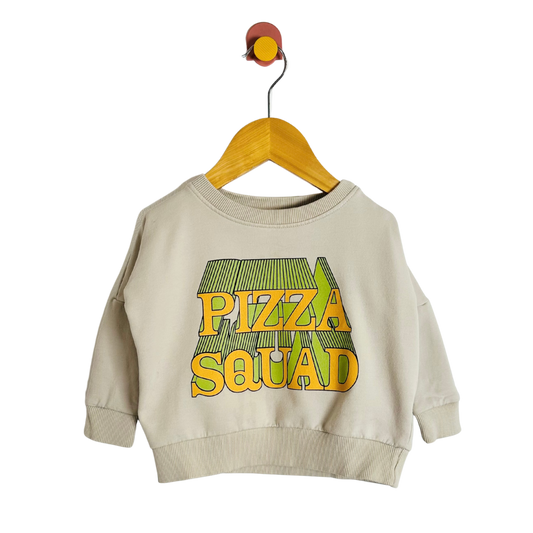 Beige sweatshirt with 'Pizza Squad' text on a hanger against a white background
