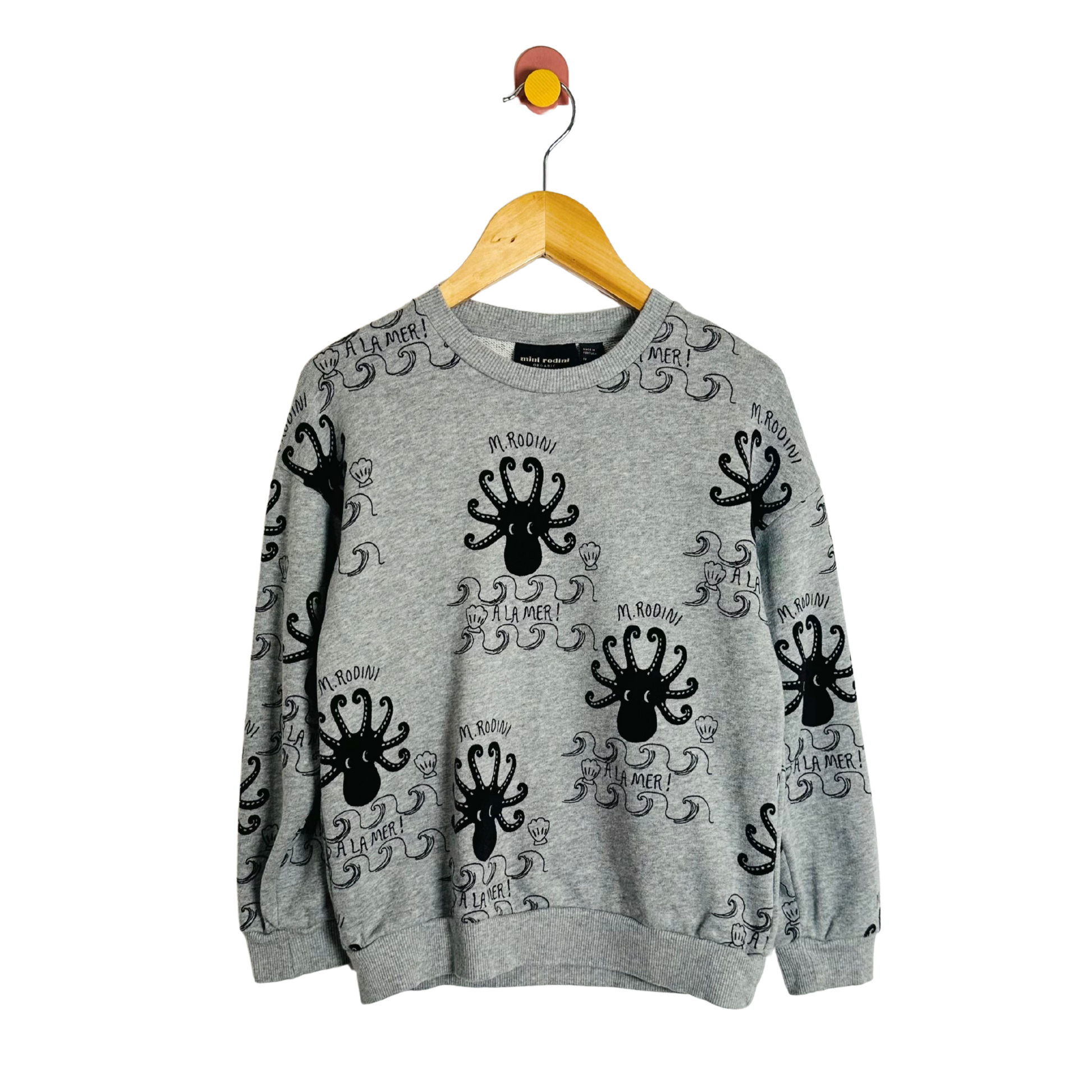 Gray sweatshirt with black octopus designs on a hanger against a white background