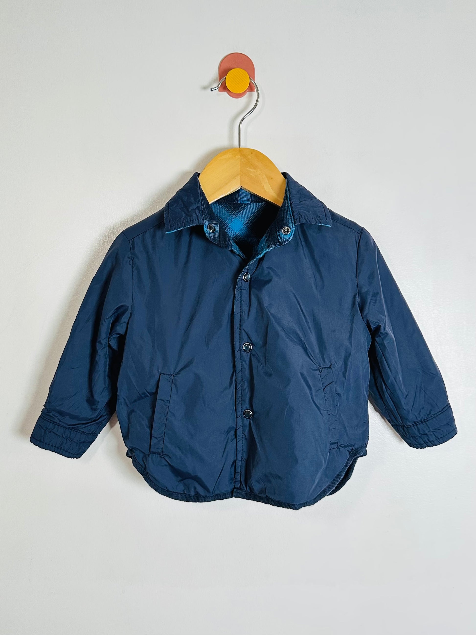 Blue jacket on a hanger against a white background