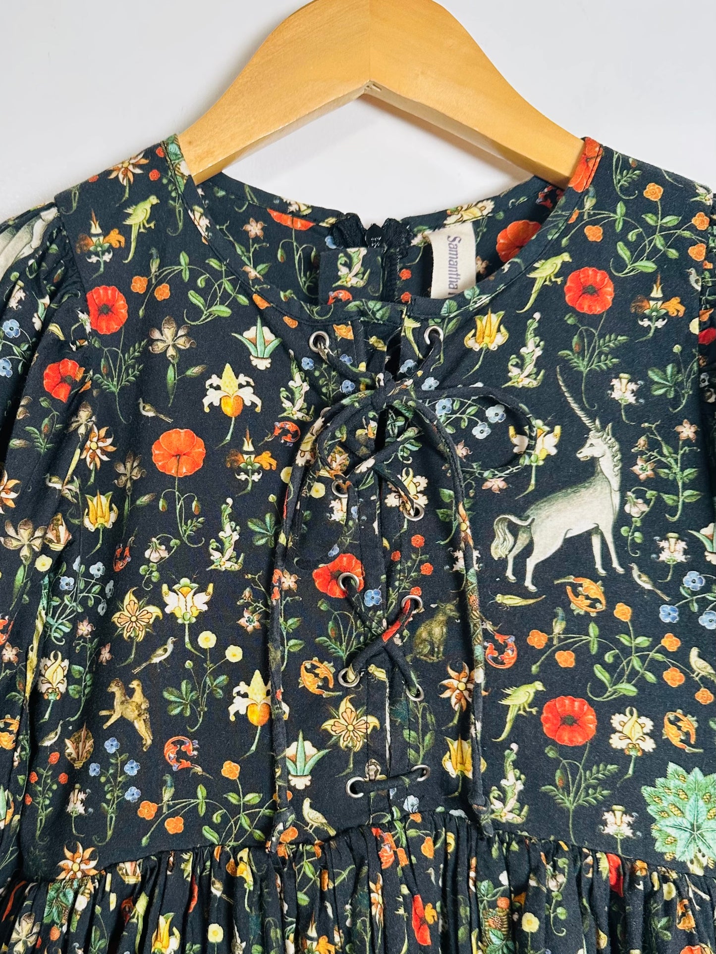 Floral patterned dress on a hanger with a white background