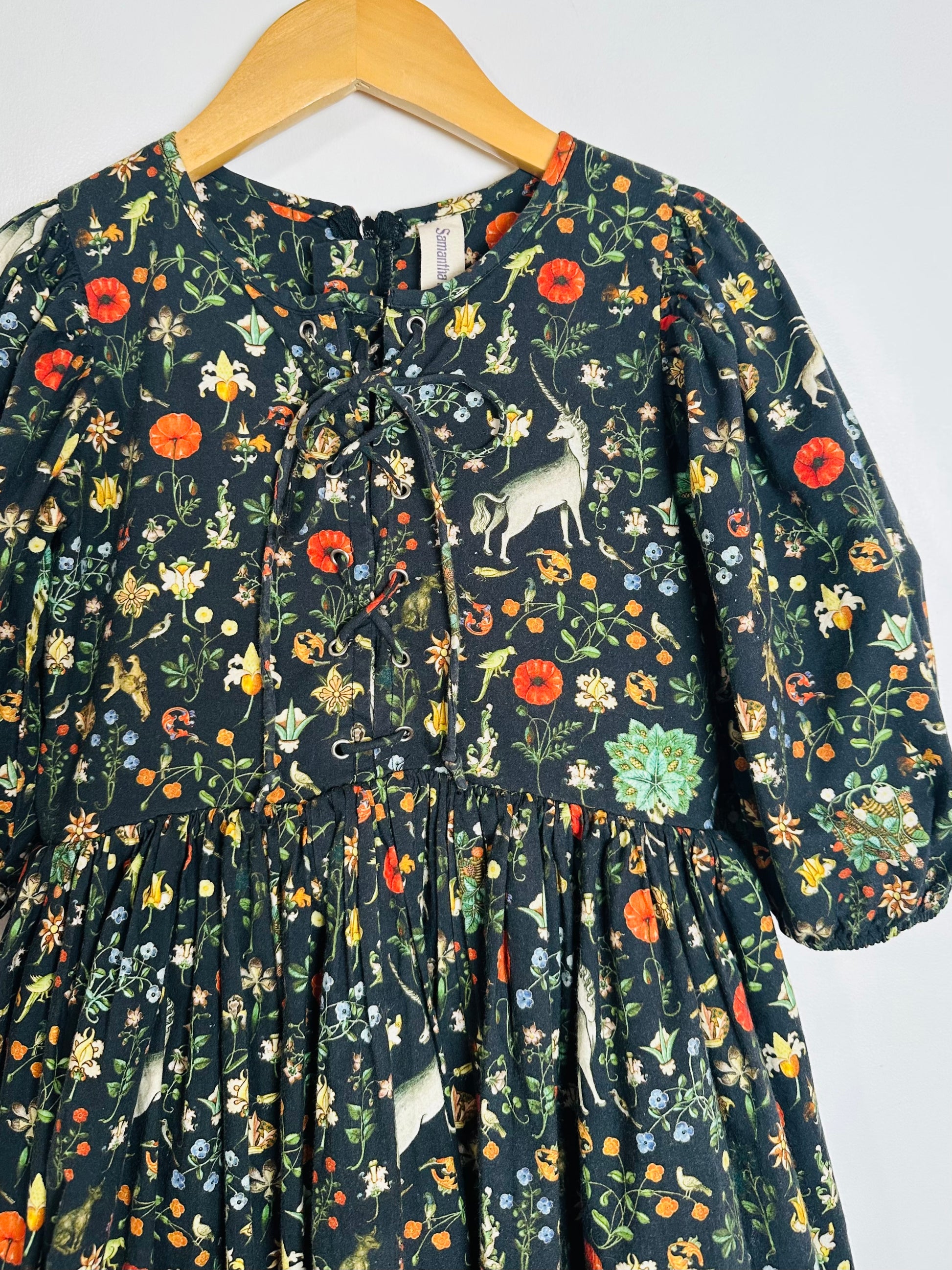 Floral patterned dress on a hanger with a white background