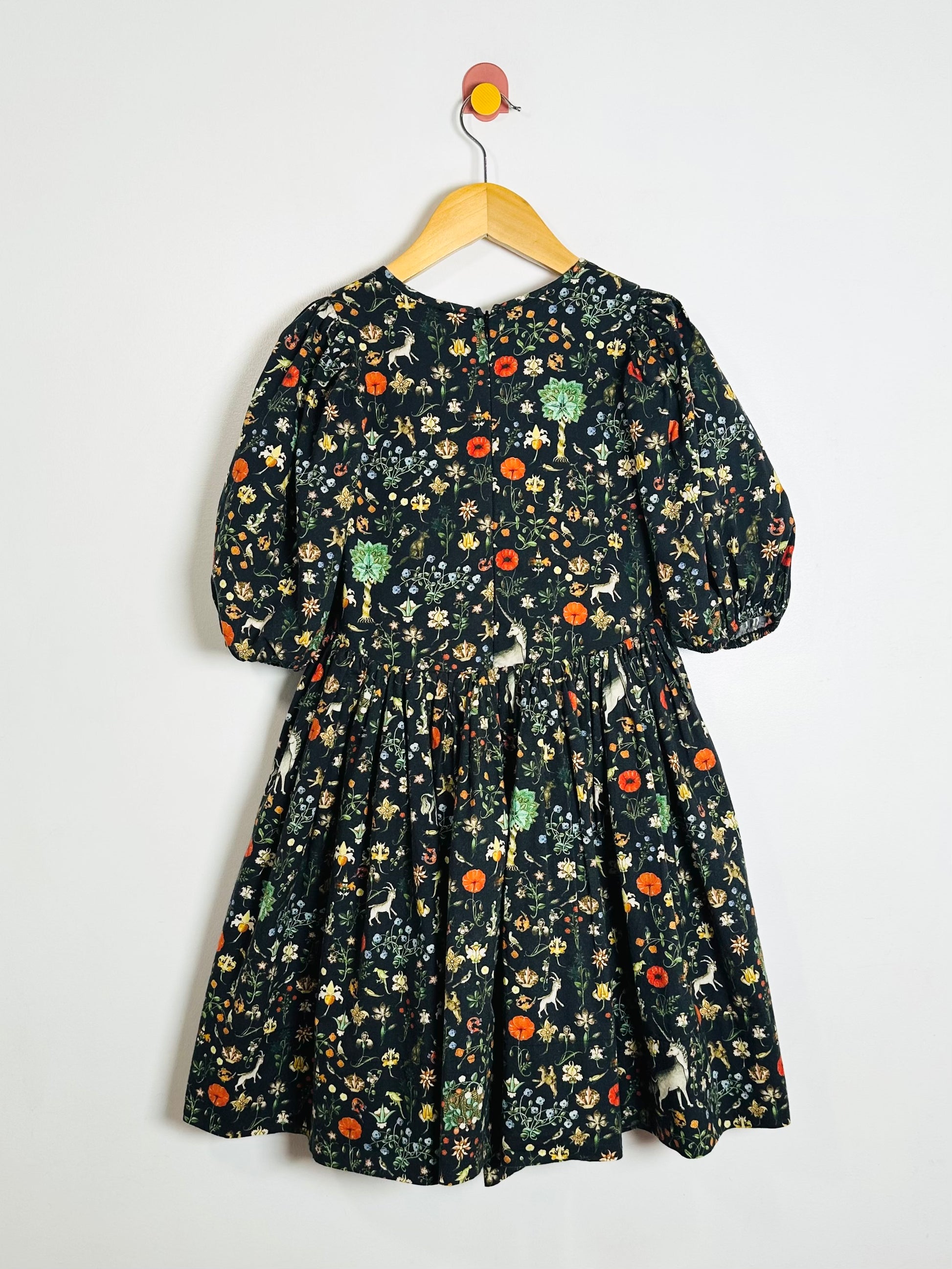 Floral dress on a hanger against a white background