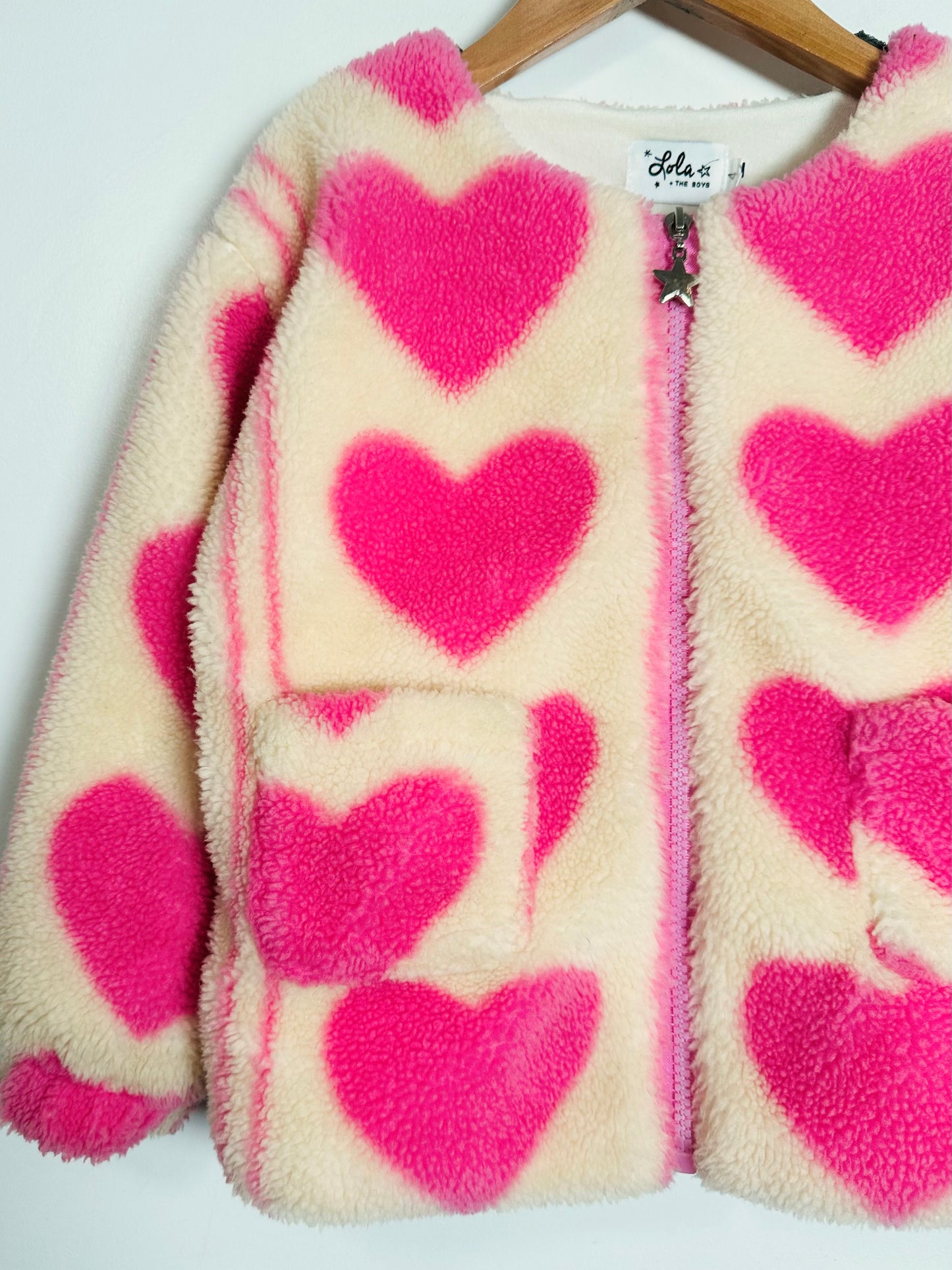 Fuzzy jacket with pink hearts on a white background