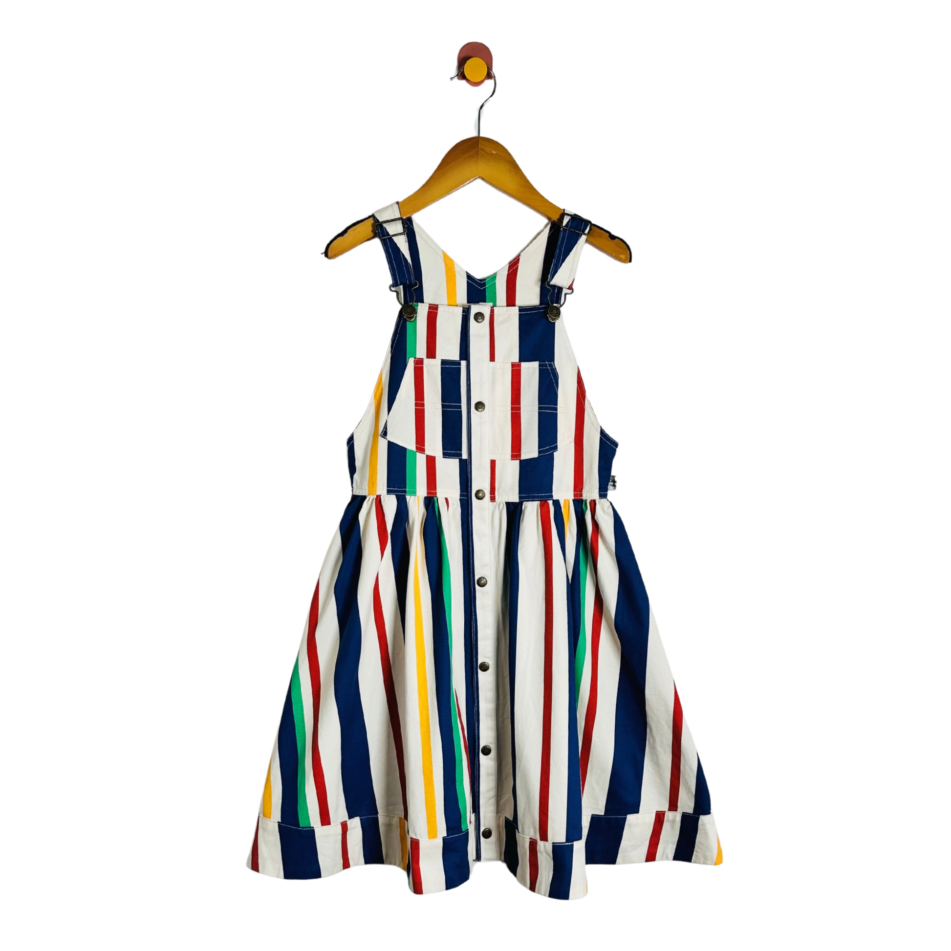 A sleeveless children's dress with a white base and vertical multicolor stripes in navy, red, yellow, green, and orange, hanging on a wooden hanger against a plain white background.