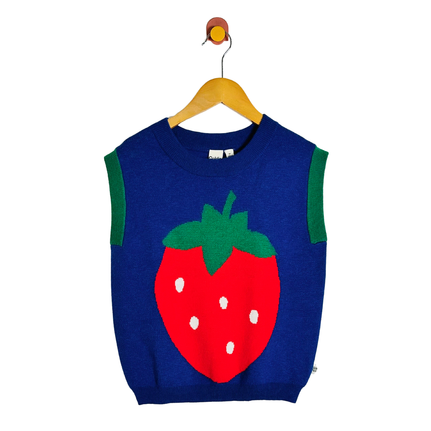 A sleeveless navy blue knit sweater vest featuring a large red strawberry graphic on the front with green leaves and white seeds, hanging on a wooden hanger against a plain white background.